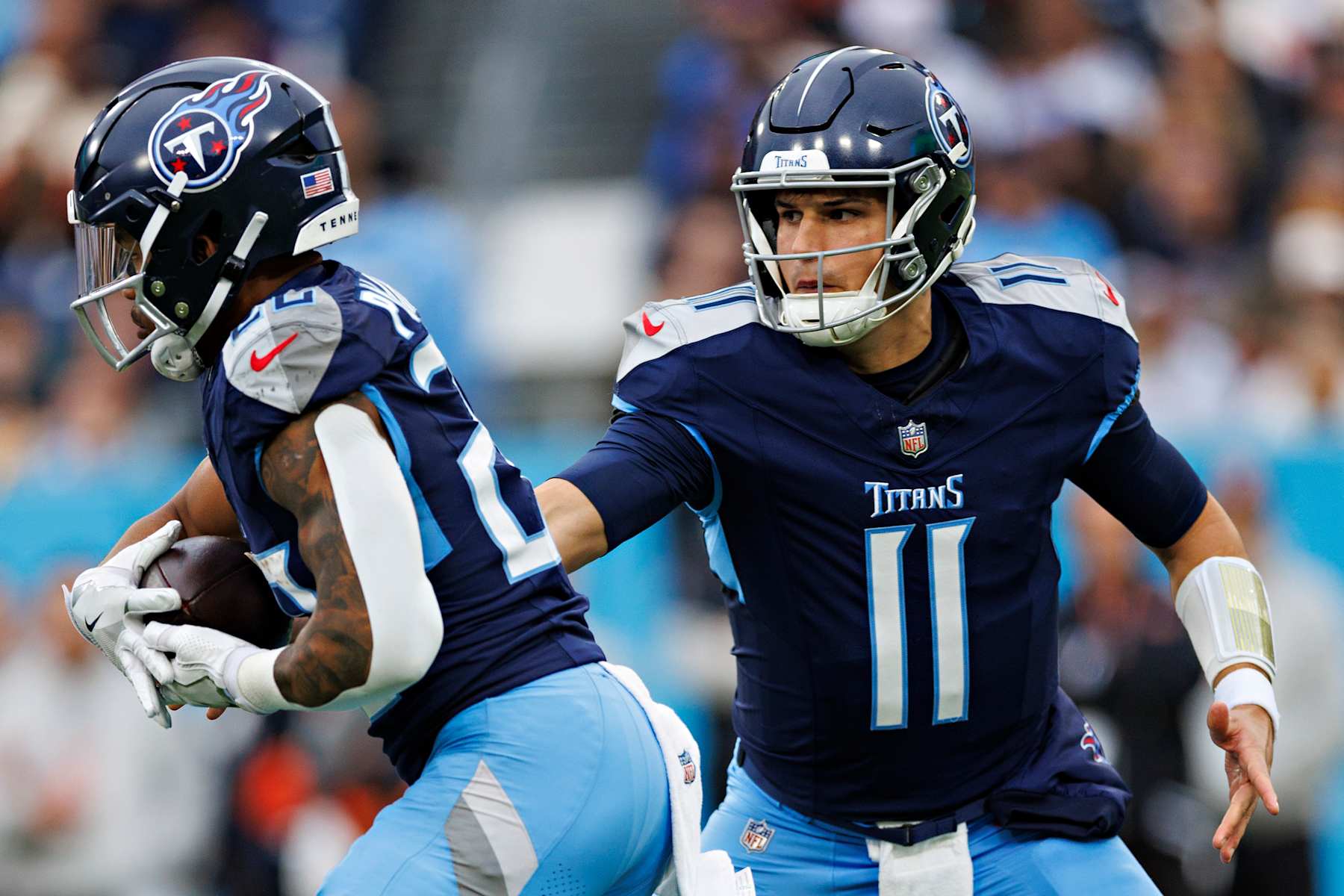 NASHVILLE, TENNESSEE - DECEMBER 15: Mason Rudolph #11 hands off the ball to Tony Pollard #20 of the Tennessee Titans during a game against the Cincinnati Bengals at Nissan Stadium on December 15, 2024 in Nashville, Tennessee. The Bengals defeated the Titans 37-27. (Photo by Wesley Hitt/Getty Images)