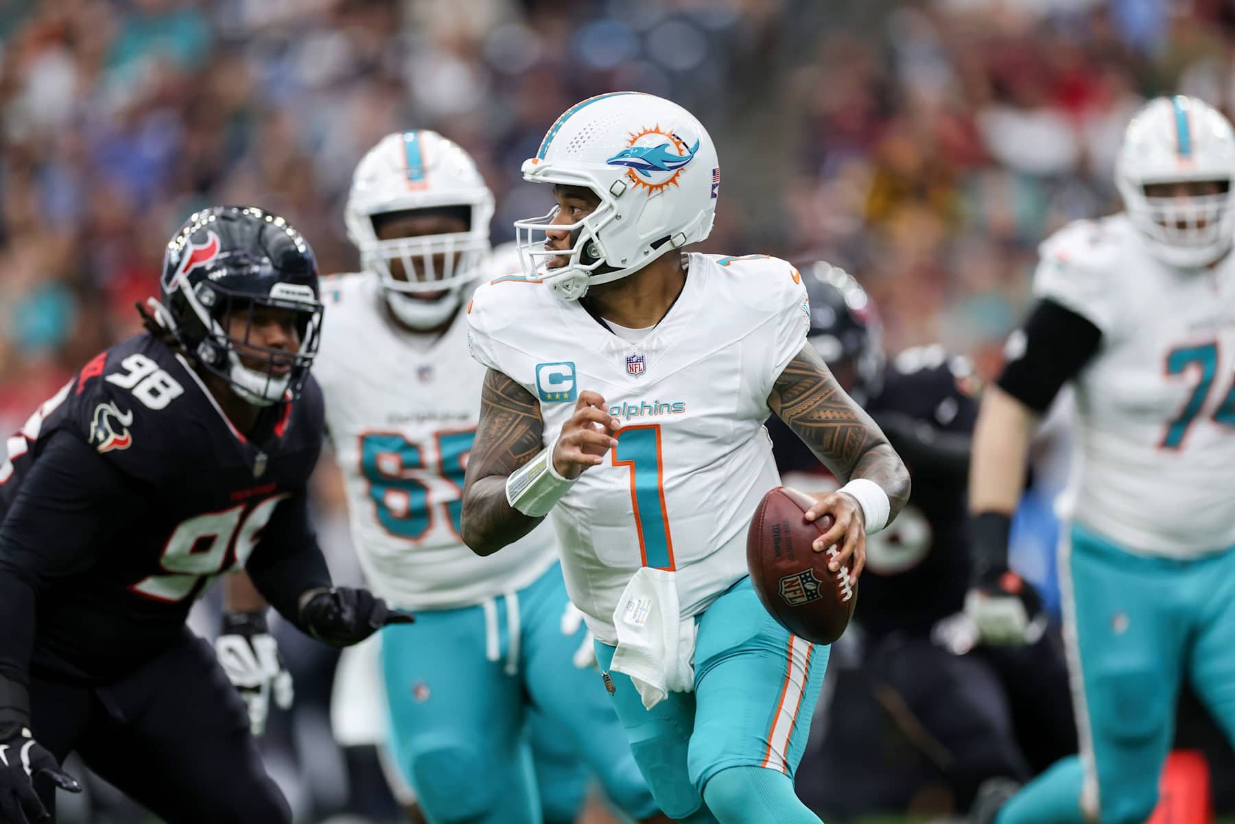 HOUSTON, TEXAS - DECEMBER 15: Tua Tagovailoa #1 of the Miami Dolphins scrambles in the first half against the Houston Texans at NRG Stadium on December 15, 2024 in Houston, Texas. (Photo by Tim Warner/Getty Images)