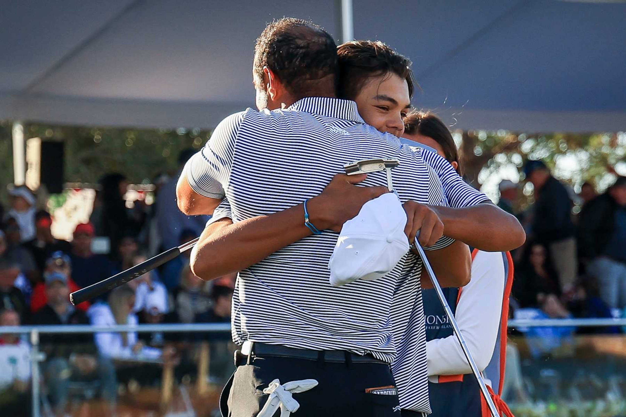 ORLANDO, FLORIDA - DECEMBER 21: Charlie Woods hugs his father Tiger Woods on the 18th hole green after their first round of the PNC Championship at Ritz-Carlton Golf Club on December 21, 2024 in Orlando, Florida. (Photo by Mike Ehrmann/Getty Images)