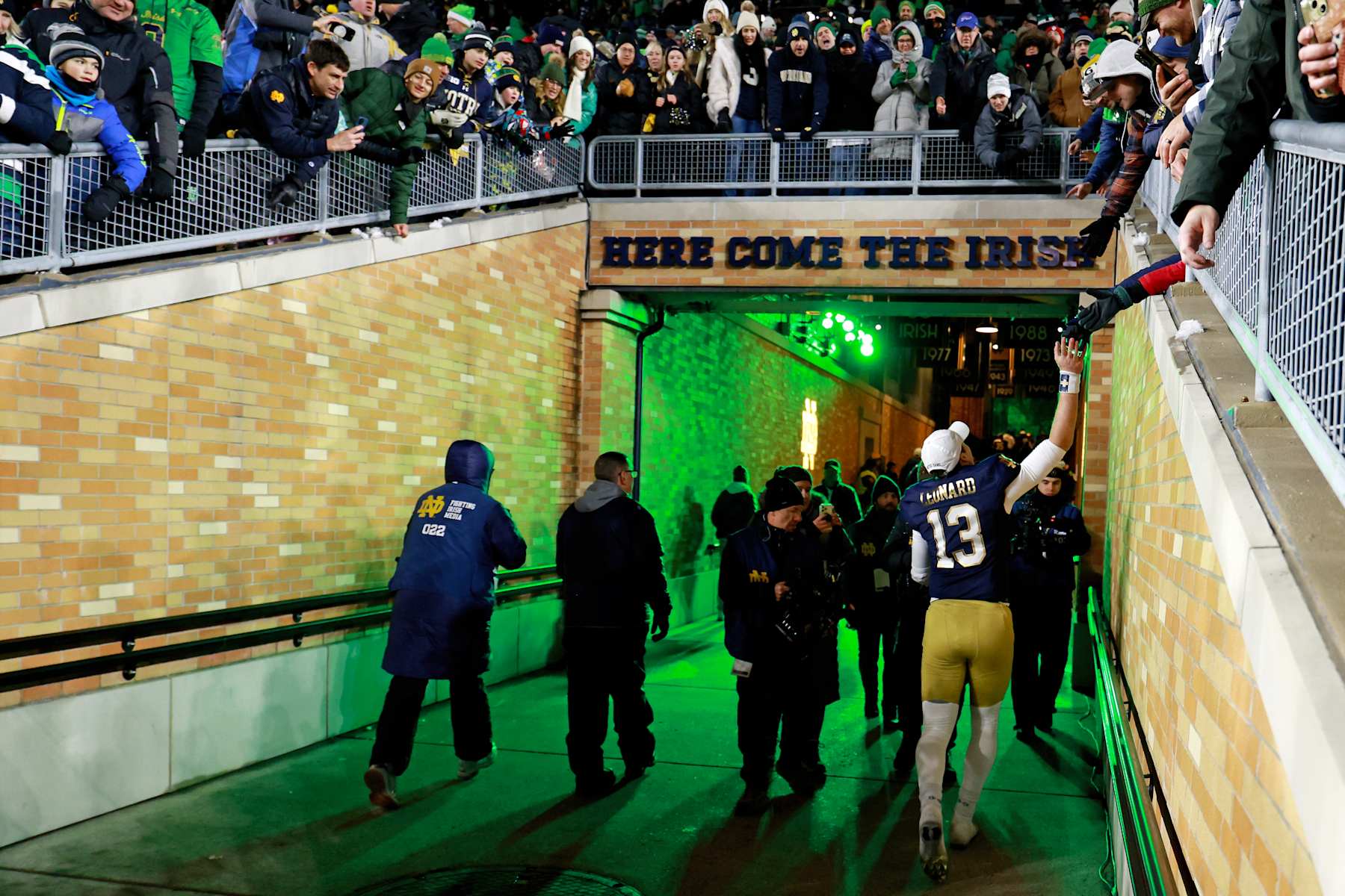 SOUTH BEND, IN - DECEMBER 20: Notre Dame Fighting Irish quarterback Riley Leonard (13) high fives fans as he walks through the tunnel to the locker room after the game against the Indiana Hoosiers on December 20, 2024, during the CFP First Round playoff game at Notre Dame Stadium in South Bend, Indiana. (Photo by Brian Spurlock/Icon Sportswire via Getty Images)