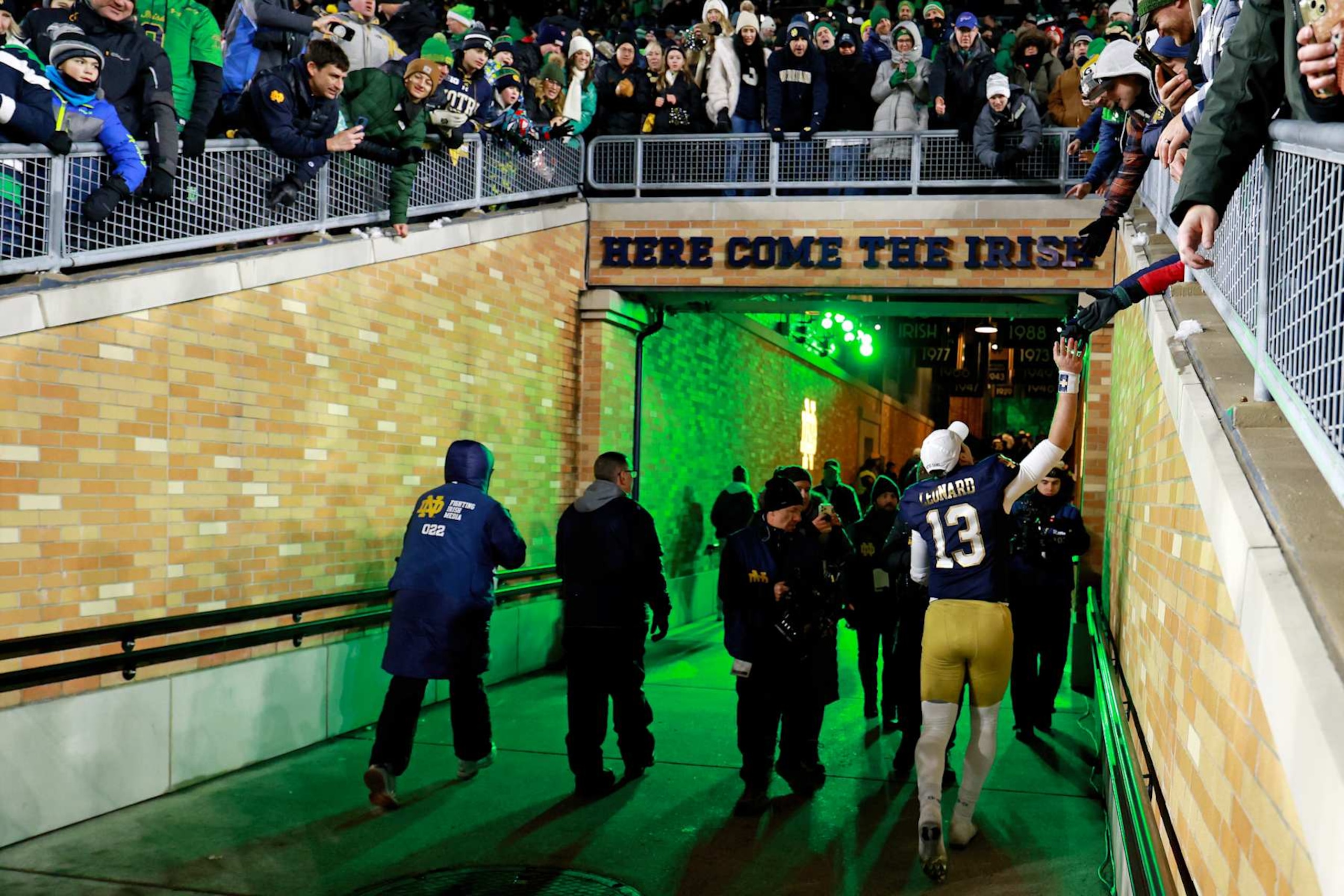 SOUTH BEND, IN - DECEMBER 20: Notre Dame Fighting Irish quarterback Riley Leonard (13) high fives fans as he walks through the tunnel to the locker room after the game against the Indiana Hoosiers on December 20, 2024, during the CFP First Round playoff game at Notre Dame Stadium in South Bend, Indiana. (Photo by Brian Spurlock/Icon Sportswire via Getty Images)