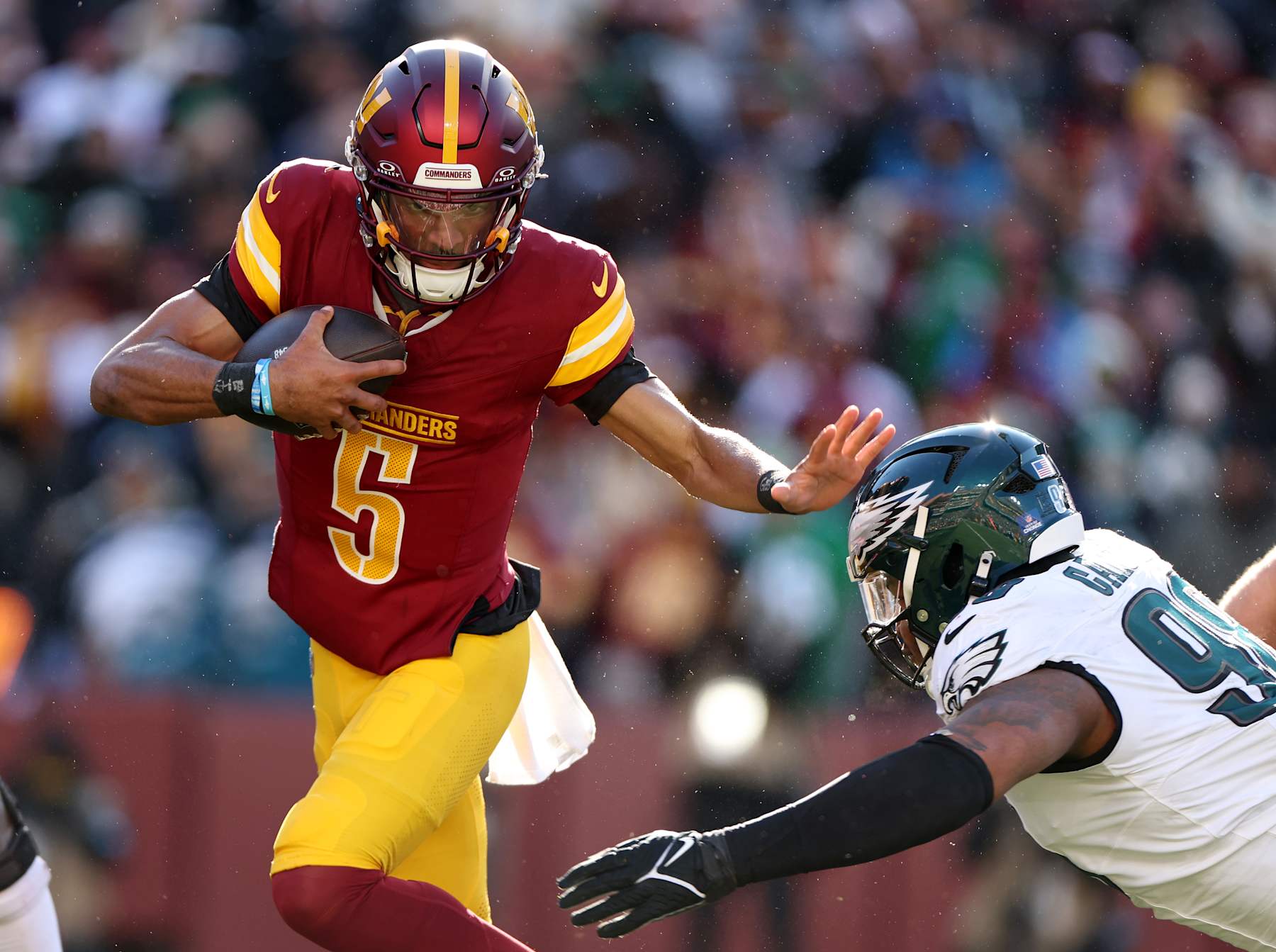 LANDOVER, MARYLAND - DECEMBER 22:  Jayden Daniels #5 of the Washington Commanders runs the ball against Jalen Carter #98 of the Philadelphia Eagles during the first quarter at Northwest Stadium on December 22, 2024 in Landover, Maryland. (Photo by Scott Taetsch/Getty Images)