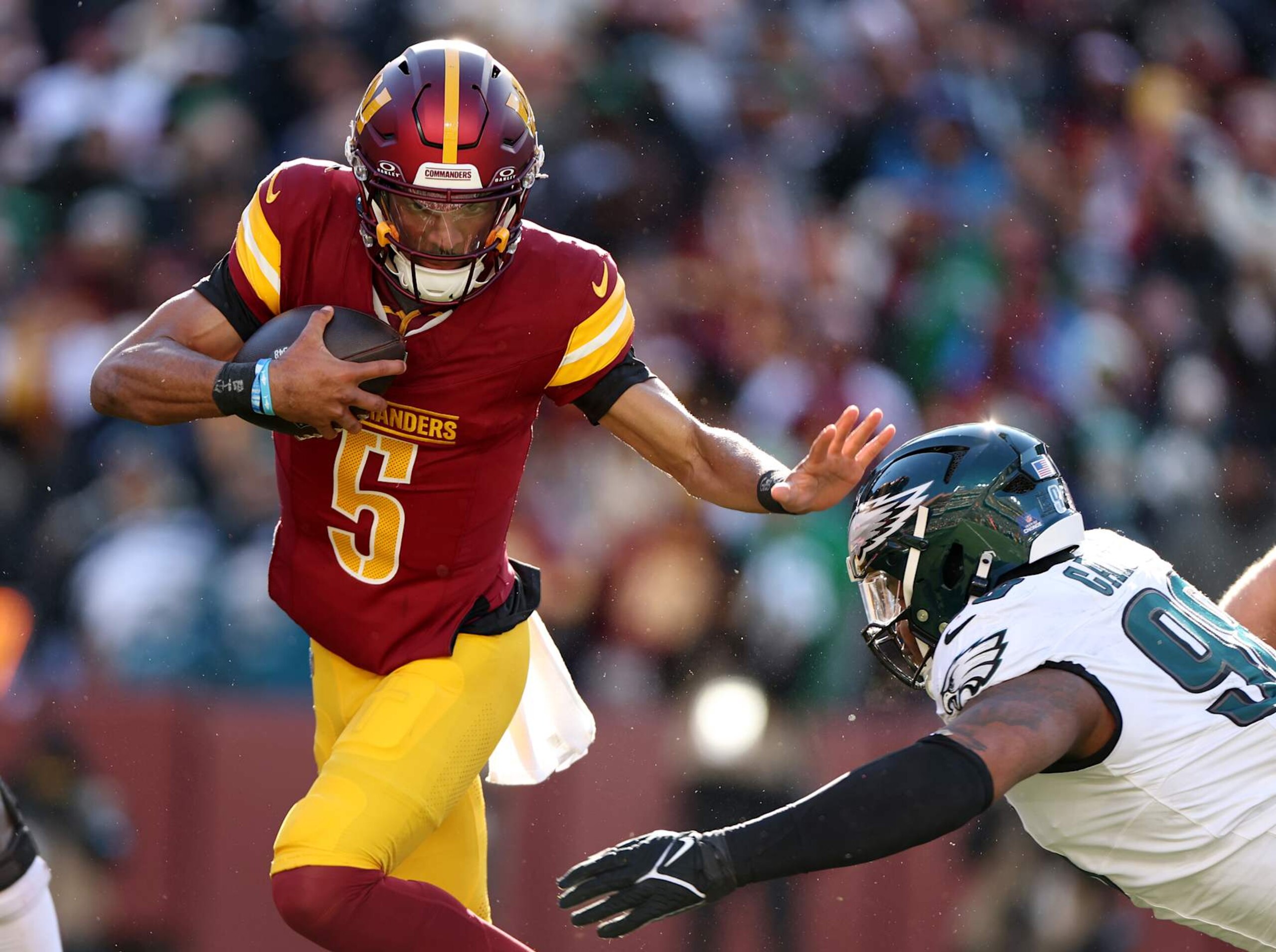 LANDOVER, MARYLAND - DECEMBER 22:  Jayden Daniels #5 of the Washington Commanders runs the ball against Jalen Carter #98 of the Philadelphia Eagles during the first quarter at Northwest Stadium on December 22, 2024 in Landover, Maryland. (Photo by Scott Taetsch/Getty Images)