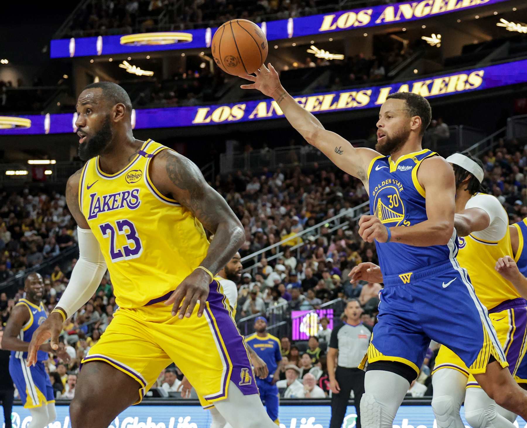 LAS VEGAS, NEVADA - OCTOBER 15: Stephen Curry #30 of the Golden State Warriors passes as LeBron James #23 of the Los Angeles Lakers defends in the first quarter of their preseason game at T-Mobile Arena at T-Mobile Arena on October 15, 2024 in Las Vegas, Nevada. The Warriors defeated the Lakers 111-97. NOTE TO USER: User expressly acknowledges and agrees that, by downloading and or using this photograph, User is consenting to the terms and conditions of the Getty Images License Agreement. (Photo by Ethan Miller/Getty Images)