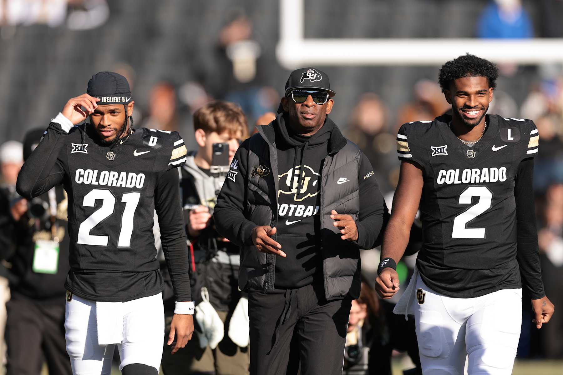 BOULDER, COLORADO - NOVEMBER 29: (L-R) Shilo Sanders #21, Head coach Deion Sanders and Shedeur Sanders #2 of the Colorado Buffaloes walk the field during senior day celebrations prior to the game against the Oklahoma State Cowboys at Folsom Field on November 29, 2024 in Boulder, Colorado. (Photo by Andrew Wevers/Getty Images)