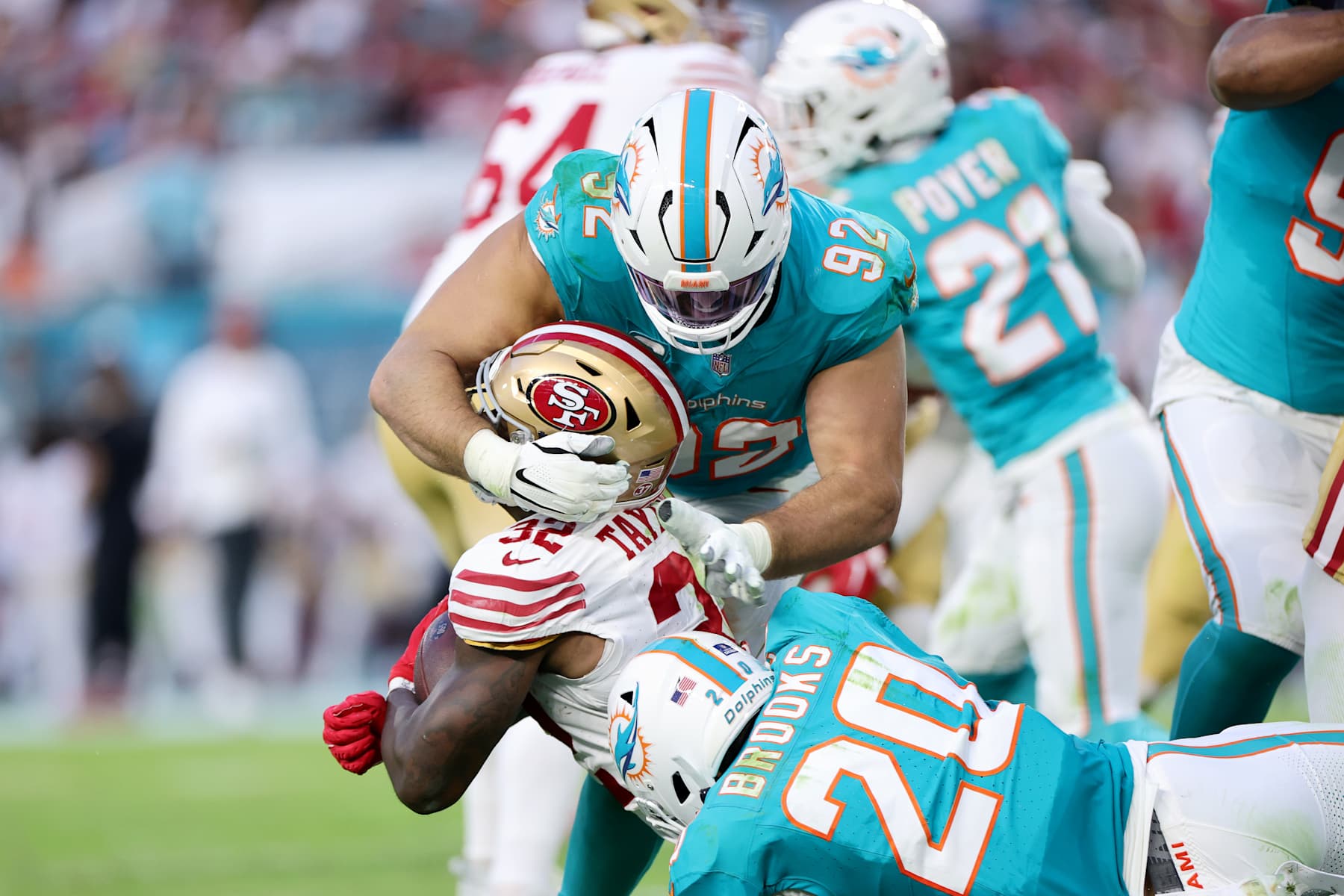 MIAMI GARDENS, FLORIDA - DECEMBER 22: Zach Sieler #92 of the Miami Dolphins tackles Patrick Taylor Jr. #32 of the San Francisco 49ers during the second quarter at Hard Rock Stadium on December 22, 2024 in Miami Gardens, Florida. (Photo by Carmen Mandato/Getty Images)