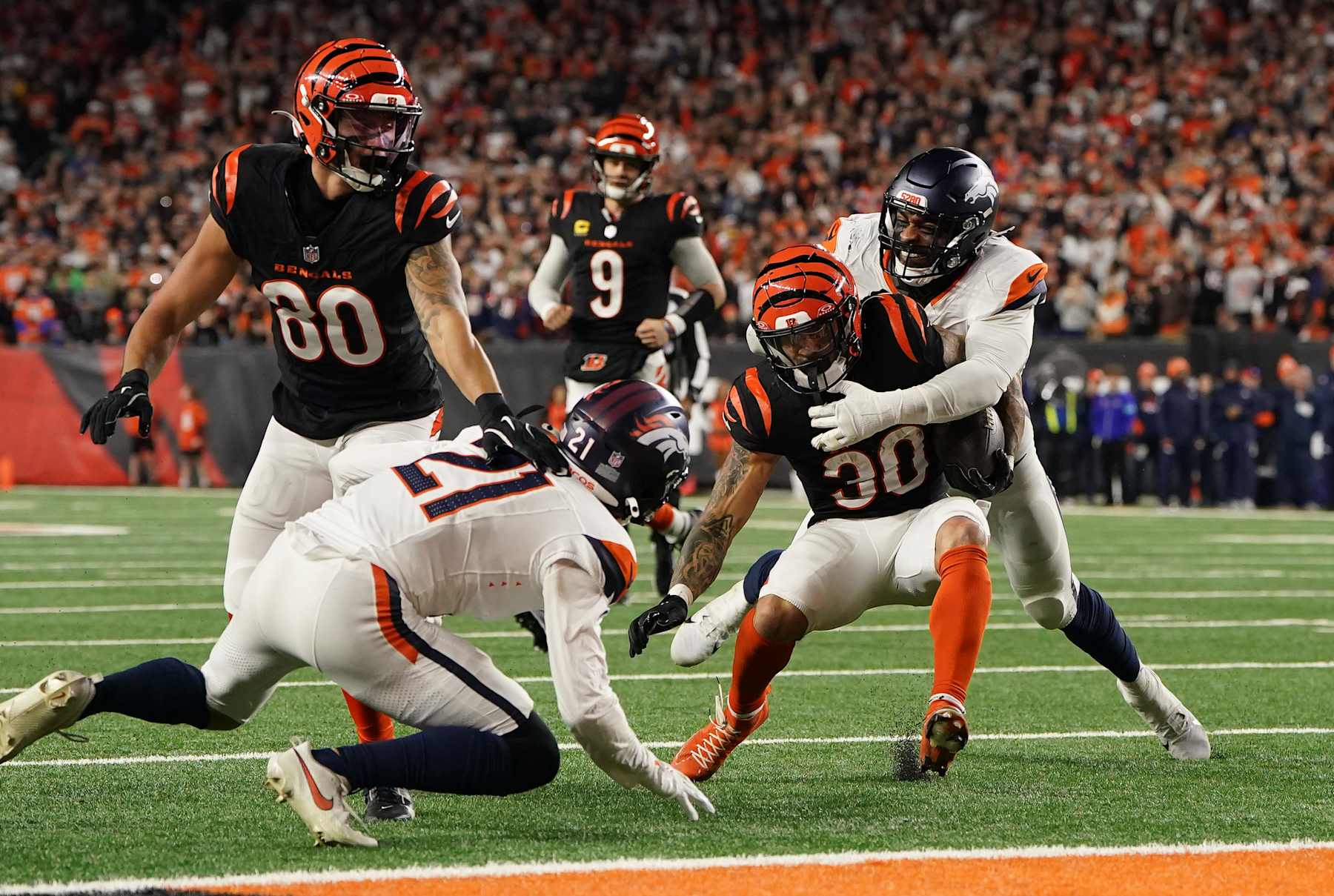 CINCINNATI, OHIO - DECEMBER 28: Jonathon Cooper #0 of the Denver Broncos tackles Chase Brown #30 of the Cincinnati Bengals during the fourth quarter at Paycor Stadium on December 28, 2024 in Cincinnati, Ohio. (Photo by Dylan Buell/Getty Images)