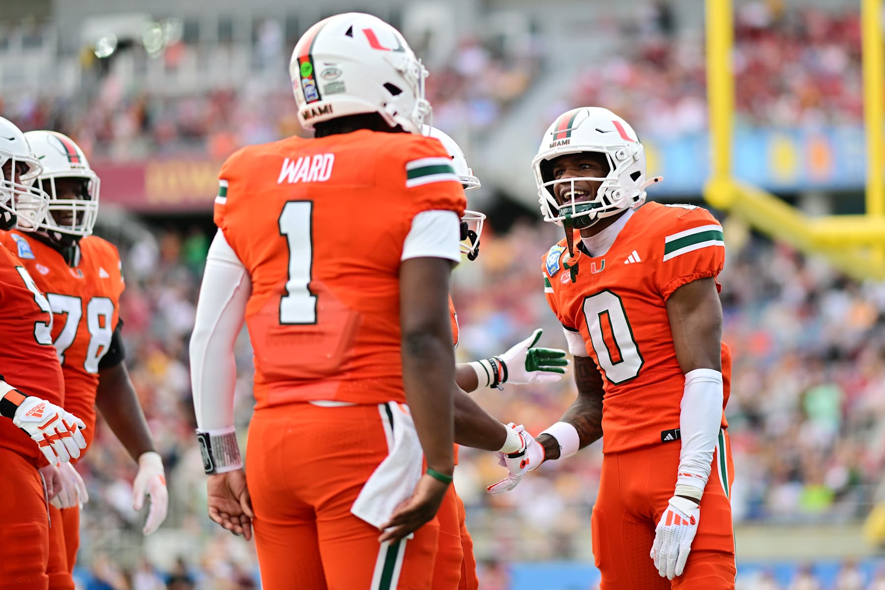 ORLANDO, FLORIDA - DECEMBER 28: Joshisa Trader #0 of the Miami Hurricanes celebrates with Cam Ward #1 after connecting for a touchdown in the second quarter against the Iowa State Cyclones during the 2024 Pop-Tarts Bowl at Camping World Stadium on December 28, 2024 in Orlando, Florida. (Photo by Julio Aguilar/Getty Images)