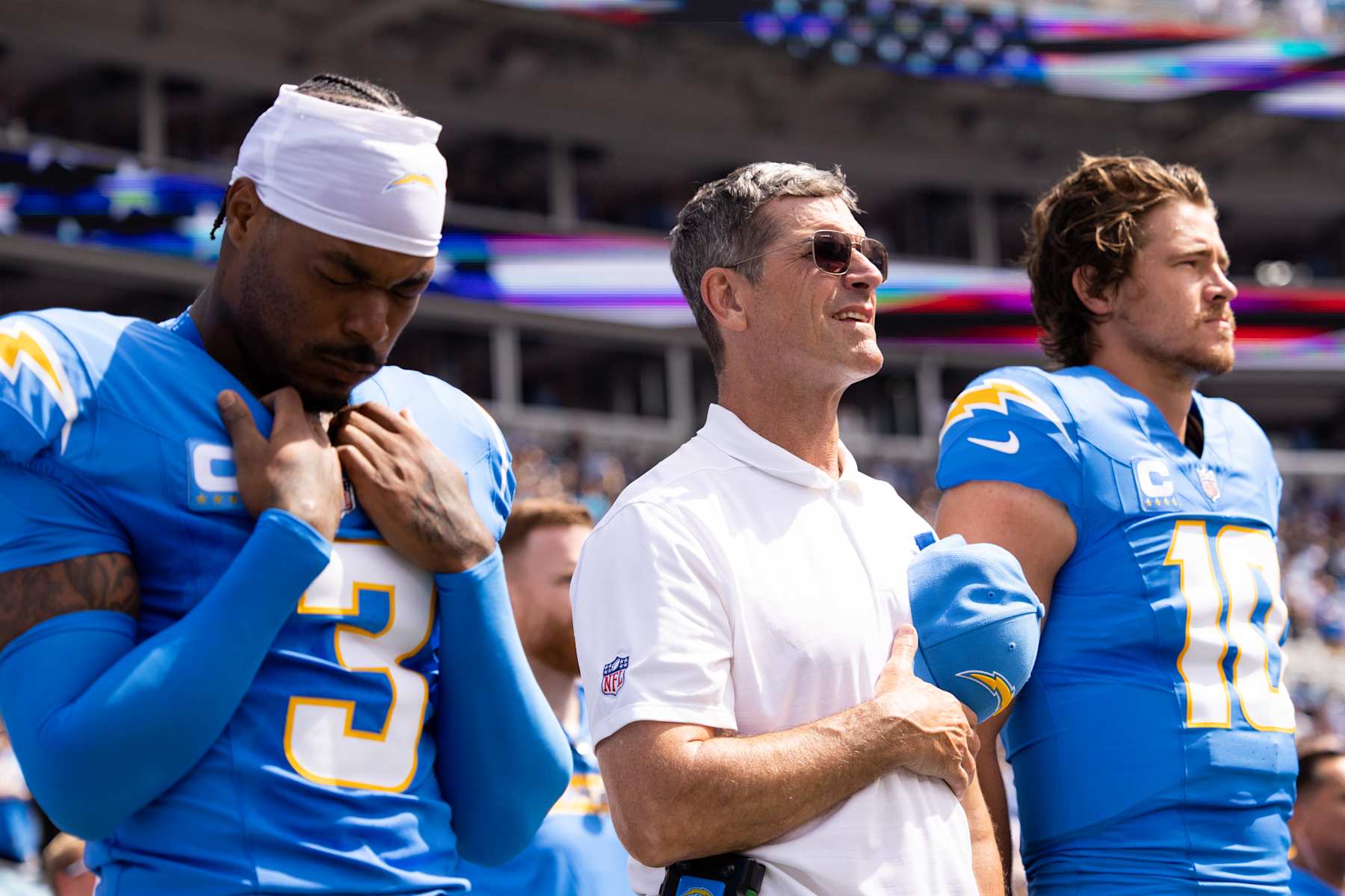 CHARLOTTE, NORTH CAROLINA - SEPTEMBER 15: Head coach Jim Harbaugh of the Los Angeles Chargers stands for the national anthem next to Derwin James Jr. #3 and Justin Herbert #10 before a game against the Carolina Panthers at Bank of America Stadium on September 15, 2024 in Charlotte, North Carolina. The Chargers defeated the Panthers 26-3. (Kara Durrette/Getty Images)