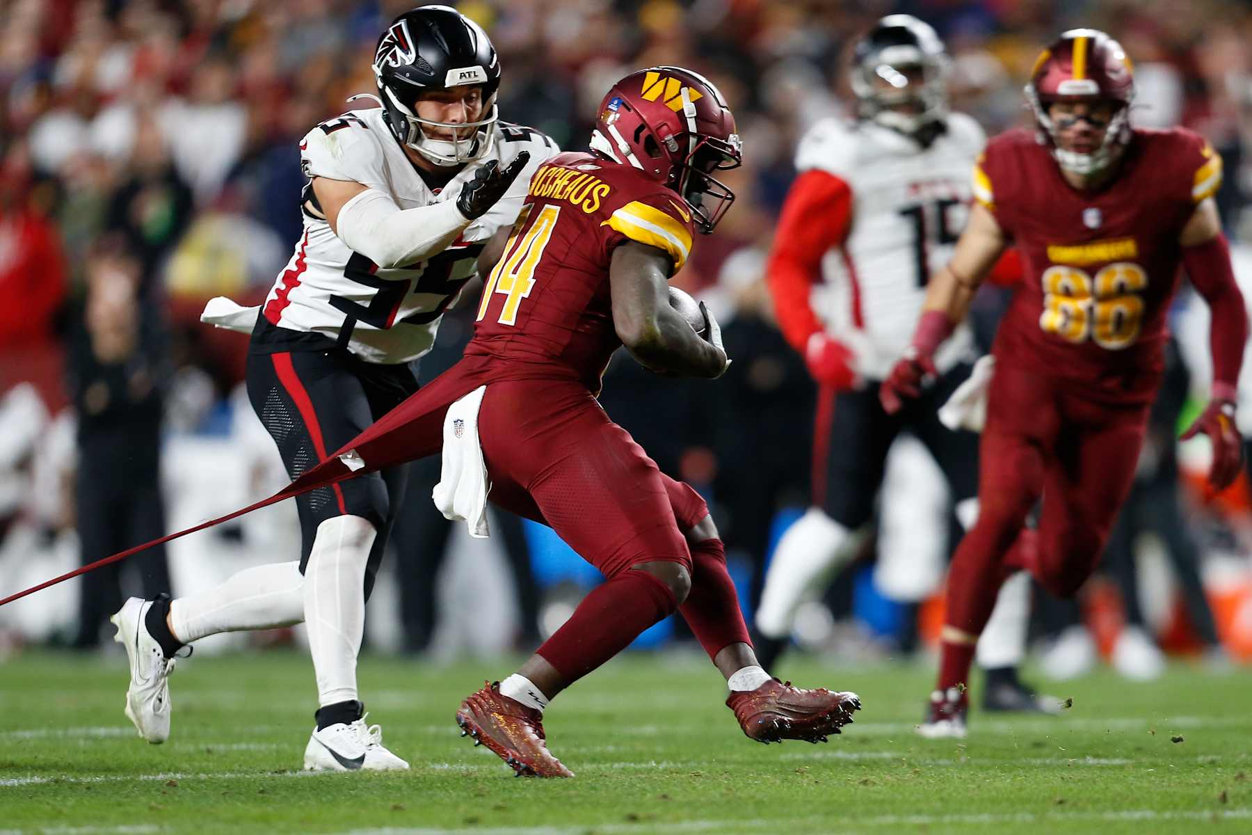 LANDOVER, MD - DECEMBER 29: Washington Commanders wide receiver Olamide Zaccheaus (14) hauls in a pass then runs upfield, maneuvering to evade Atlanta Falcons linebacker Kaden Elliss (55) during the Atlanta Falcons game versus the Washington Commanders at Northwest Stadium on December 29, 2024, in Landover, MD. (Photo by Lee Coleman/Icon Sportswire via Getty Images)