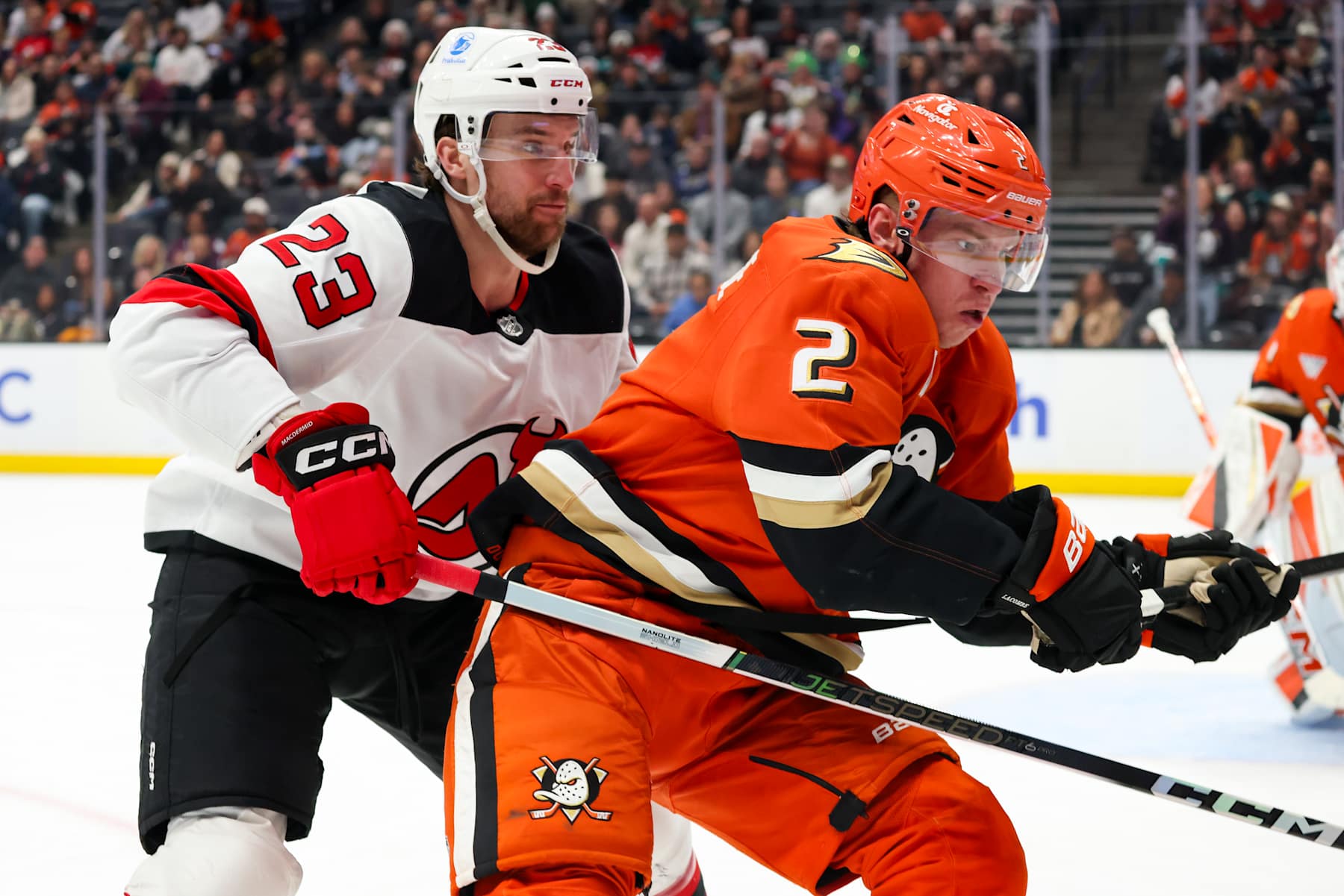 ANAHEIM, CA - DECEMBER 31: Kurtis MacDermid #23 of the New Jersey Devils and Jackson LaCombe #2 of the Anaheim Ducks battle for position during the second period Honda Center on December 31, 2024 in Anaheim, California. (Photo by Debora Robinson/NHLI via Getty Images)