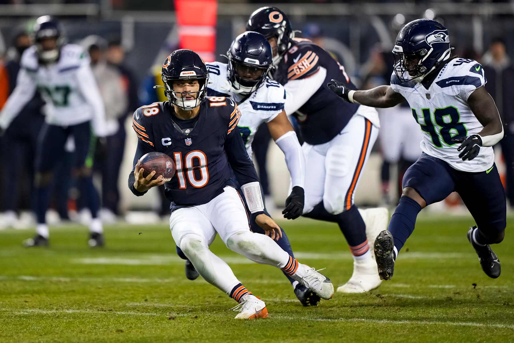 CHICAGO, ILLINOIS - DECEMBER 26: Quarterback Caleb Williams #18 of the Chicago Bears scrambles out of the pocket during the third quarter of an NFL football game against the Seattle Seahawks, at Soldier Field on December 26, 2024 in Chicago, Illinois. (Photo by Todd Rosenberg/Getty Images)
