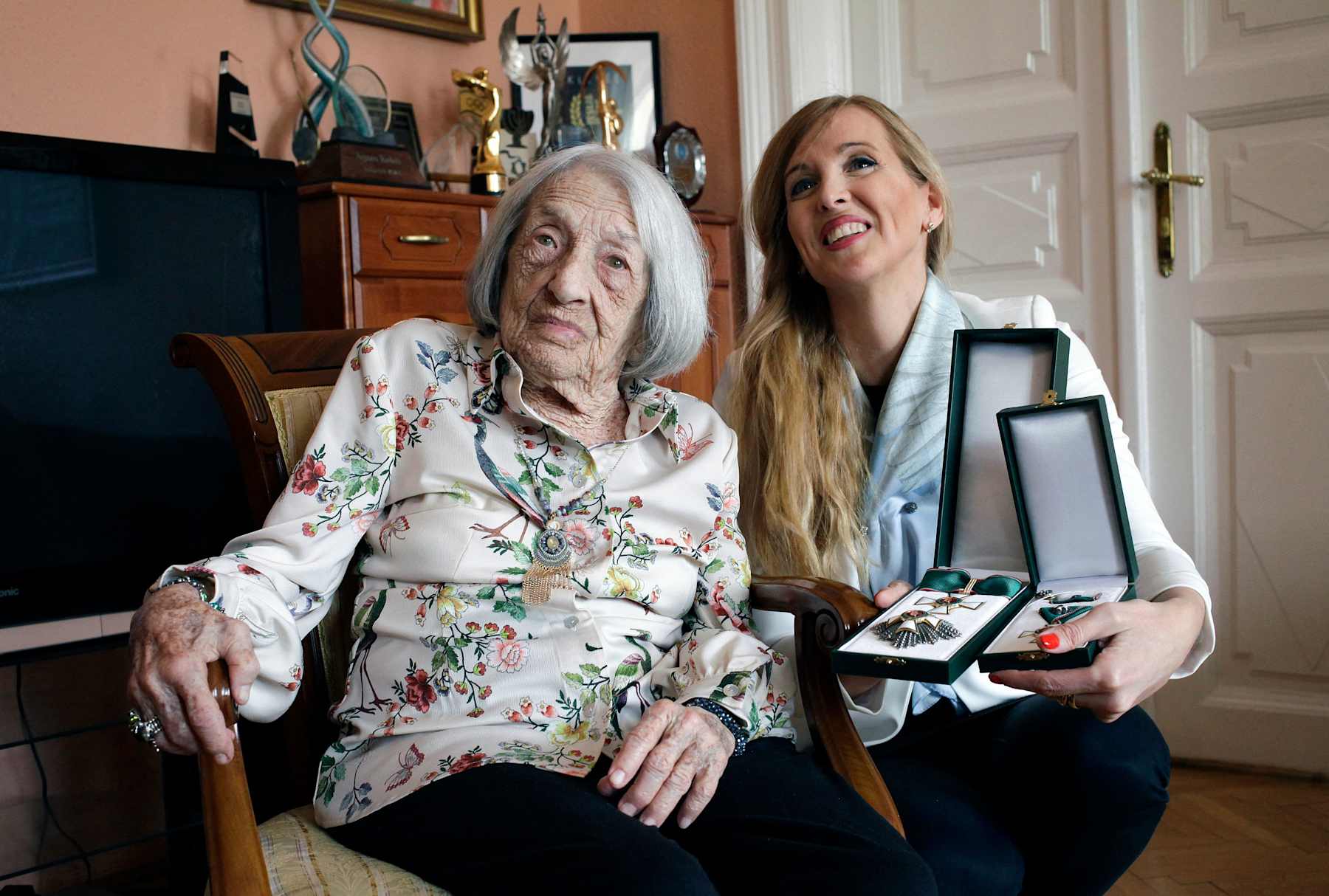 Hungarian-Israeli retired Olympic and world champion artistic gymnast Agnes Keleti (L) poses with Hungarian State Secretary for Sports Tunde Szabo after she was presented with the Hungarian Order of Merit (cross with star) in Keleti's apartment in Budapest on April 7, 2022. - 101-year-old Agnes Keleti, a survivor of the Holocaust, won 10 Olympic medals in Helsinki (1952) and in Melbourne (1956) and is considered to be the world's oldest living Olympian. (Photo by Peter Kohalmi / AFP) (Photo by PETER KOHALMI/AFP via Getty Images)