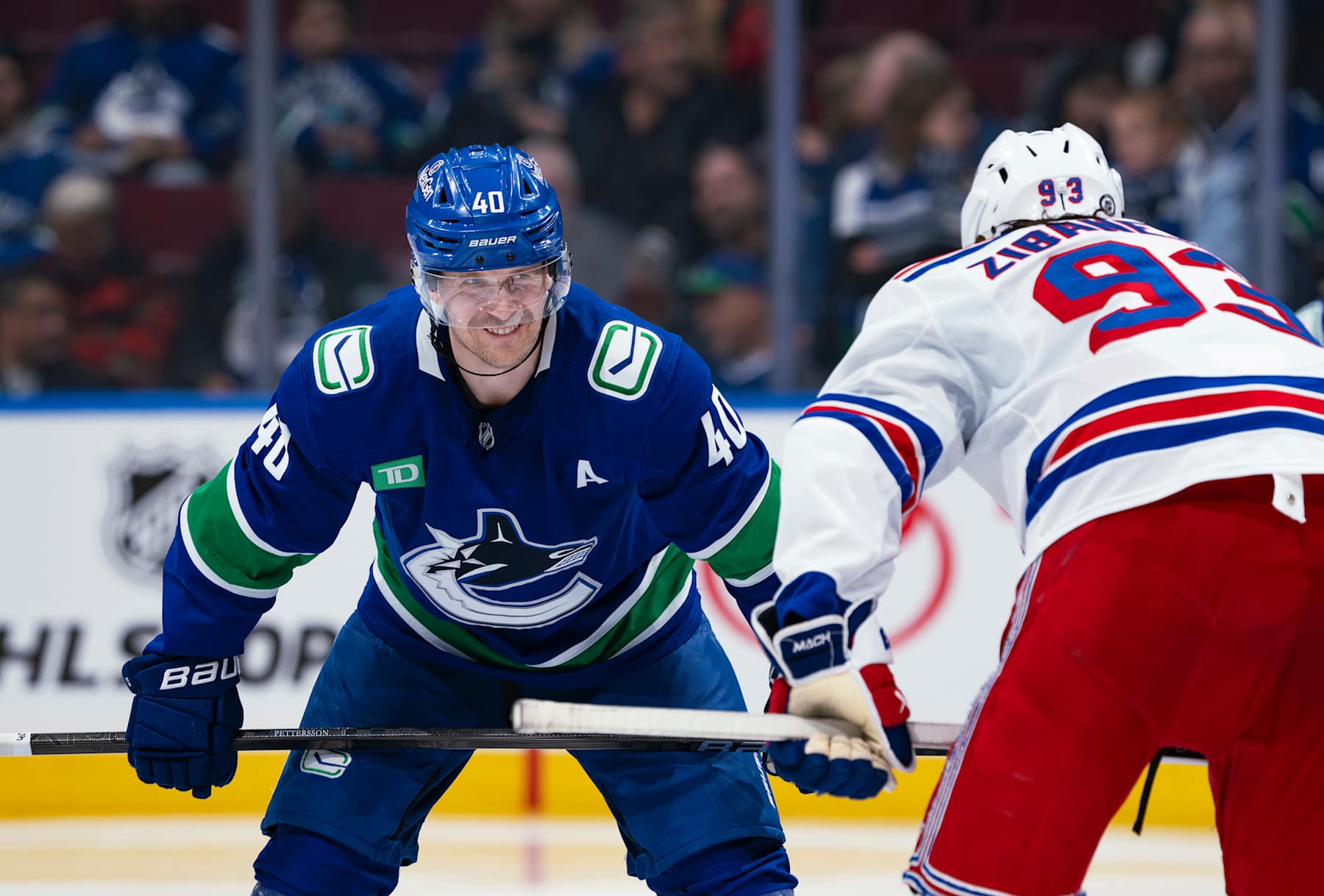 VANCOUVER, CANADA - NOVEMBER 19: Elias Pettersson #40 of the Vancouver Canucks and Mika Zibanejad #93 of the New York Rangers line up for a face off during their NHL game at Rogers Arena on November 19, 2024 in Vancouver, British Columbia, Canada. (Photo by Jeff Vinnick/NHLI via Getty Images)