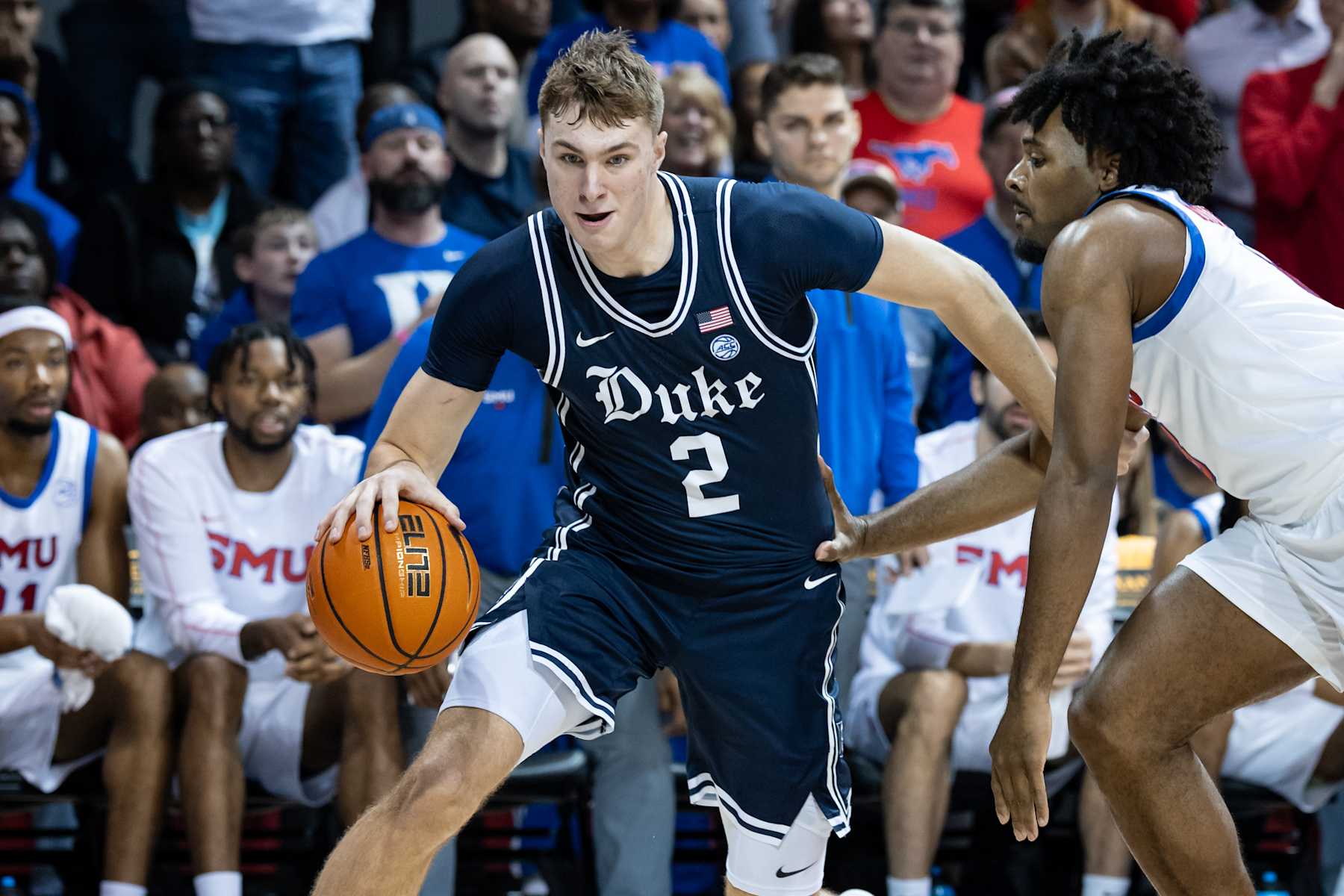 DALLAS, TX - JANUARY 04: Duke Blue Devils forward Cooper Flagg (#2) dribbles past SMU Mustangs guard Kario Oquendo (#8) along the baseline during the college basketball game between the SMU Mustangs and the Duke Blue Devils on January 4, 2025, at Moody Coliseum in Dallas, TX.  (Photo by Matthew Visinsky/Icon Sportswire via Getty Images)