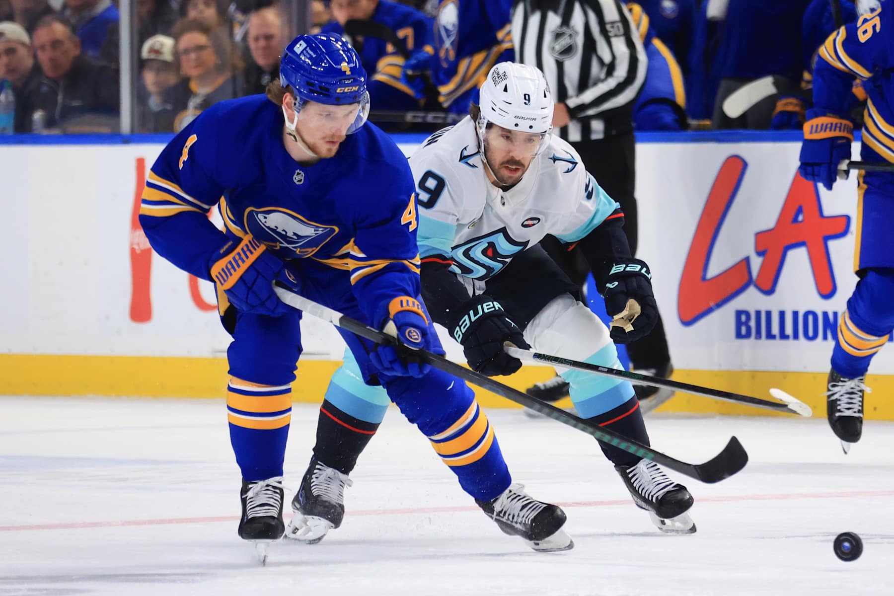 BUFFALO, NEW YORK - JANUARY 11: Bowen Byram #4 of the Buffalo Sabres and Chandler Stephenson #9 of the Seattle Kraken battle for the puck during an NHL game on January 11, 2025 at KeyBank Center in Buffalo, New York. (Photo by Bill Wippert/NHLI via Getty Images)