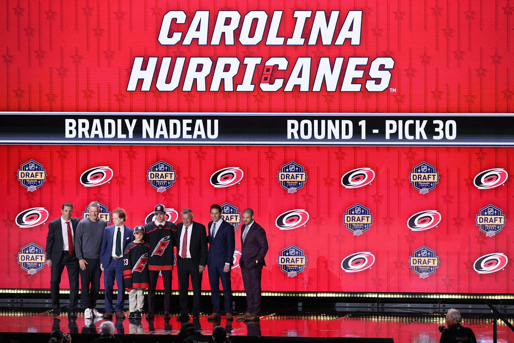 NASHVILLE, TN - JUNE 28: Carolina Hurricanes draft pick Bradly Nadeau poses for a photo on stage with team management during the first round of the Upper Deck NHL Draft, June 28, 2023 at Bridgestone Arena in Nashville, Tennessee. (Photo by Matthew Maxey/Icon Sportswire via Getty Images)