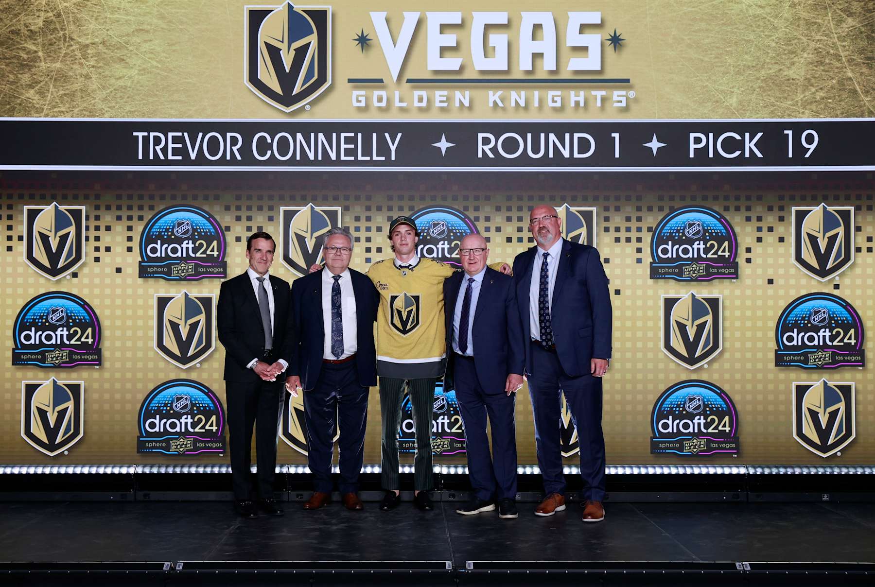 LAS VEGAS, NEVADA - JUNE 28: Trevor Connelly poses for a group photo with president George McPhee, general manager Kelly McCrimmon and team personnel after being selected 19th overall by the Vegas Golden Knights during the first round of the 2024 Upper Deck NHL Draft at Sphere on June 28, 2024 in Las Vegas, Nevada. (Photo by Jeff Vinnick/NHLI via Getty Images)