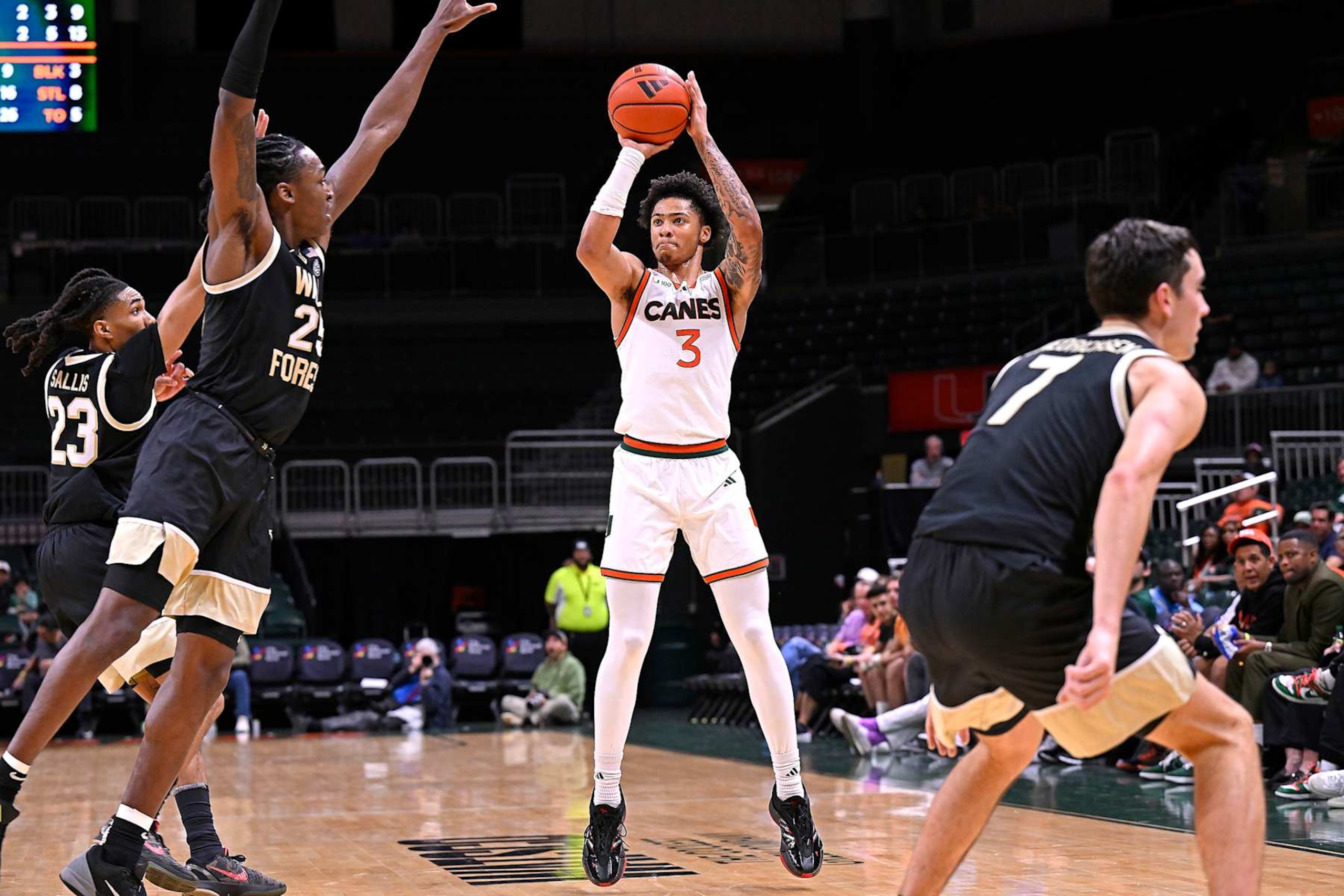 CORAL GABLES, FL - JANUARY 11: Miami guard Jalil Bethea (3) shoots a jump shot while defended by Wake Forest forward Tre'Von Spillers (25) and guard Hunter Sallis (23) in the second half as the Miami Hurricanes faced the Wake Forest Demon Decons on January 11, 2025, at the Watsco Center in Coral Gables, Florida. (Photo by Samuel Lewis/Icon Sportswire via Getty Images)