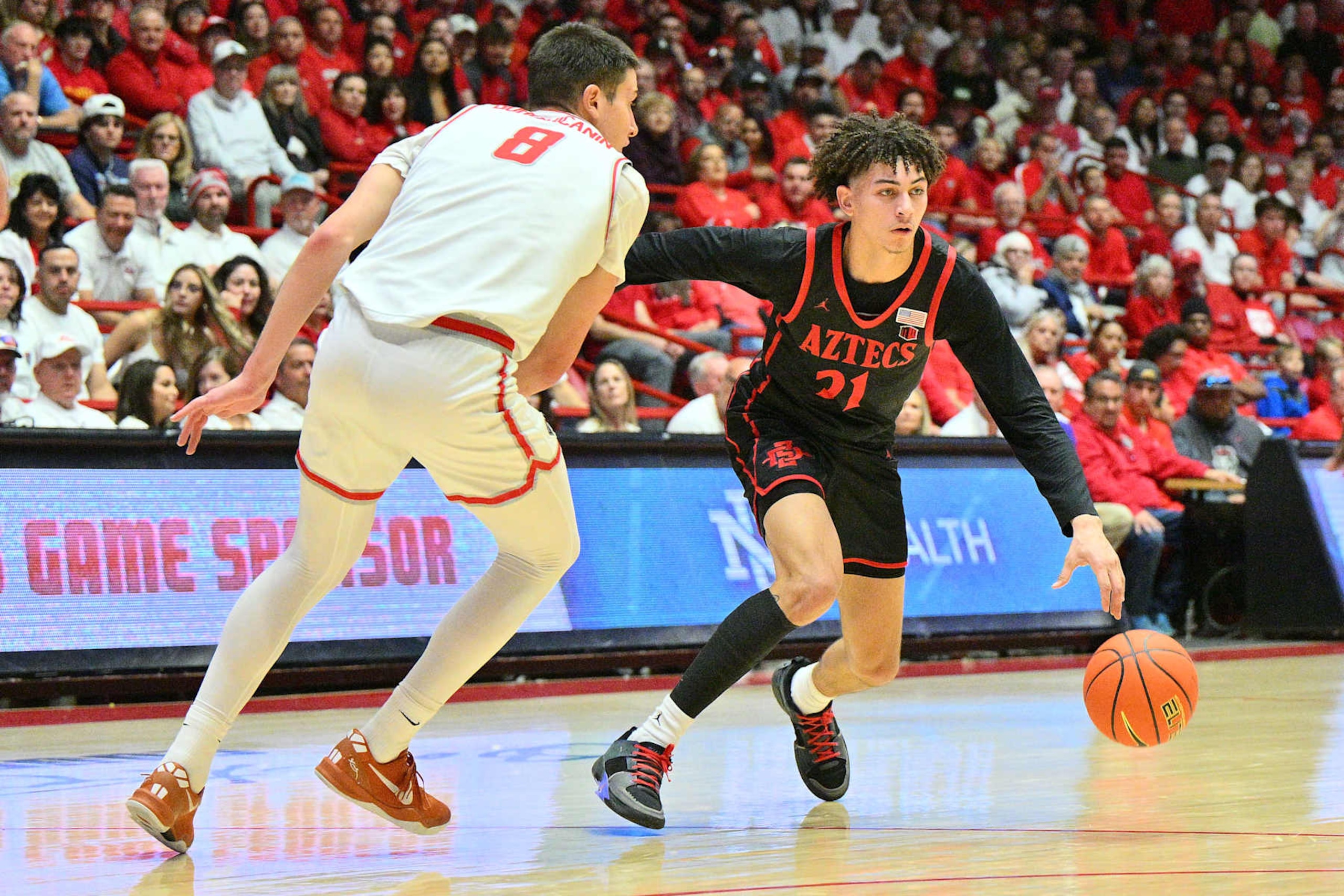ALBUQUERQUE, NEW MEXICO - JANUARY 11: Miles Byrd #21 of the San Diego State Aztecs drives against Filip Borovicanin #8 of the New Mexico Lobos during the first half of a game at The Pit on January 11, 2025 in Albuquerque, New Mexico. (Photo by Sam Wasson/Getty Images)