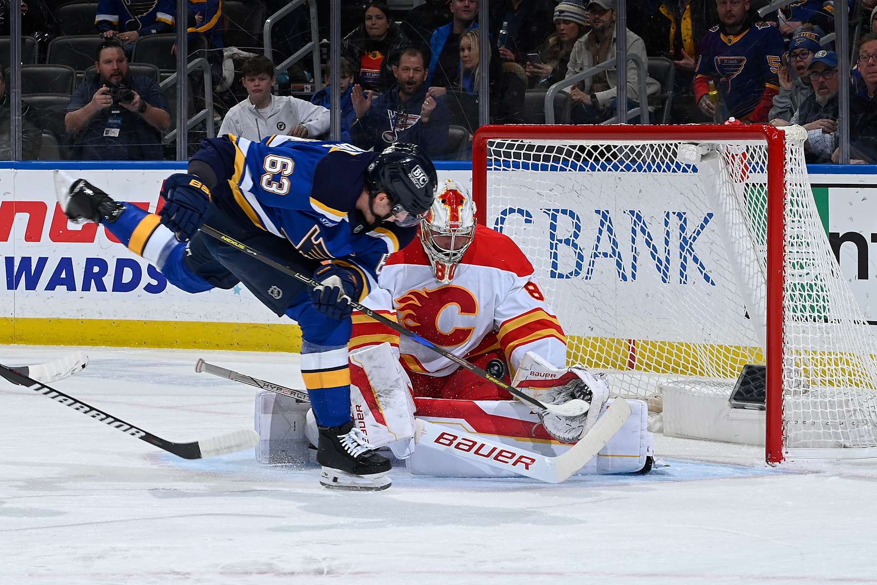 ST. LOUIS, MO - JANUARY 14: Dan Vladar #80 of the Calgary Flames blocks a shot from Jake Neighbours #63 of the St. Louis Blues on January 14, 2025 at the Enterprise Center in St. Louis, Missouri. (Photo by Alexis R. Knight/NHLI via Getty Images)