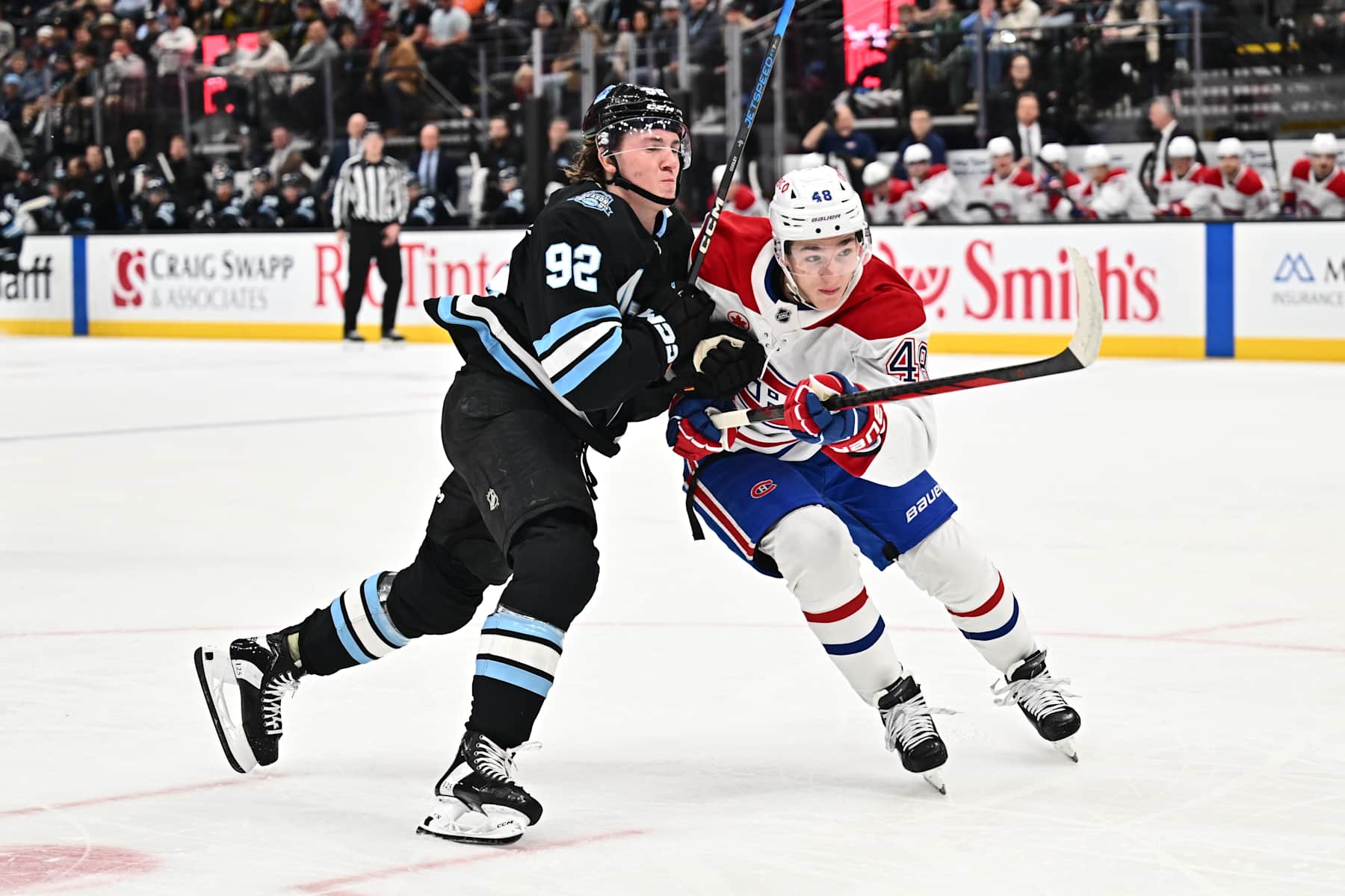 SALT LAKE CITY, UTAH - JANUARY 14: Logan Cooley #92 of the Utah Hockey Club and Lane Hutson #48 of the Montreal Canadiens battle for position as they skate after a loose puck during the first period of a game on January 14, 2025 at Delta Center in Salt Lake City, Utah. (Photo by Jamie Sabau/NHLI via Getty Images)