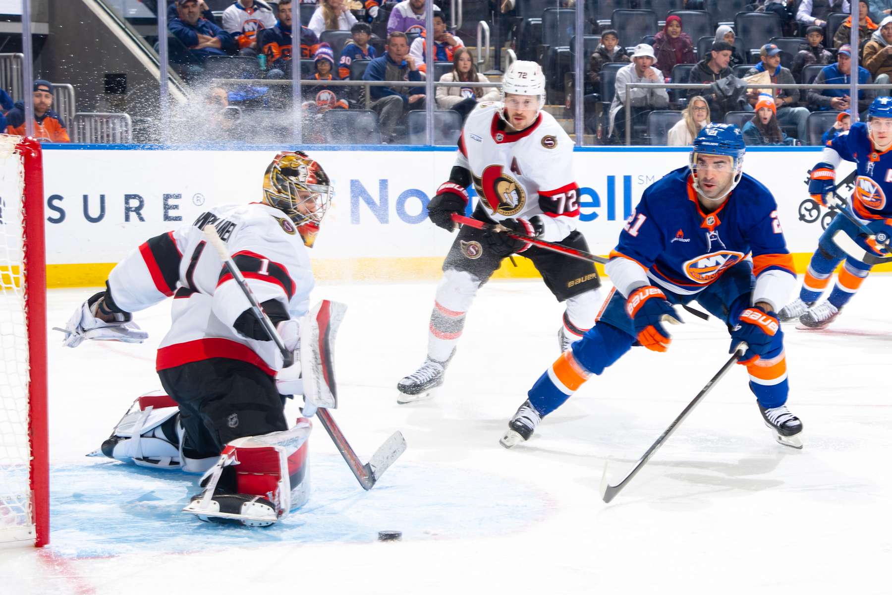 ELMONT, NEW YORK - JANUARY 14: Leevi Merilainen #1 of the Ottawa Senators makes a save against Kyle Palmieri #21 of the New York Islanders during the first period at UBS Arena on January 14, 2025 in Elmont, New York. (Photo by Mike Stobe/NHLI via Getty Images)