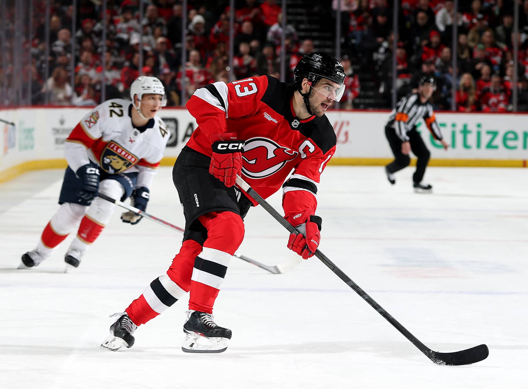 NEWARK, NEW JERSEY - JANUARY 14: Nico Hischier #13 of the New Jersey Devils heads for the net as Gustav Forsling #42 of the Florida Panthers defends during the second period at Prudential Center on January 14, 2025 in Newark, New Jersey. (Photo by Elsa/Getty Images)