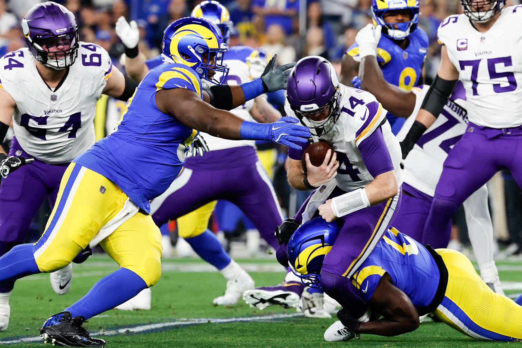 GLENDALE, AZ - JANUARY 13: Los Angeles Rams defensive tackle Kobie Turner, left, and linebacker Byron Young sack Minnesota Vikings quarterback Sam Darnold during the first quarter of the NFC Wildcard game at State Farm Stadium on Monday, Jan. 13, 2025 in Glendale, AZ. (Gina Ferazzi / Los Angeles Times via Getty Images)