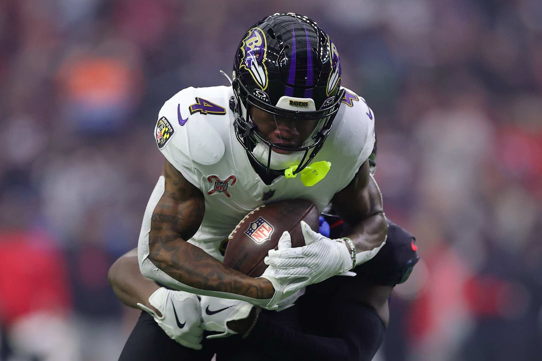 HOUSTON, TEXAS - DECEMBER 25: Zay Flowers #4 of the Baltimore Ravens runs the ball after a catch Kamari Lassiter #4 of the Houston Texans during the first quarter at NRG Stadium on December 25, 2024 in Houston, Texas. (Photo by Alex Slitz/Getty Images)