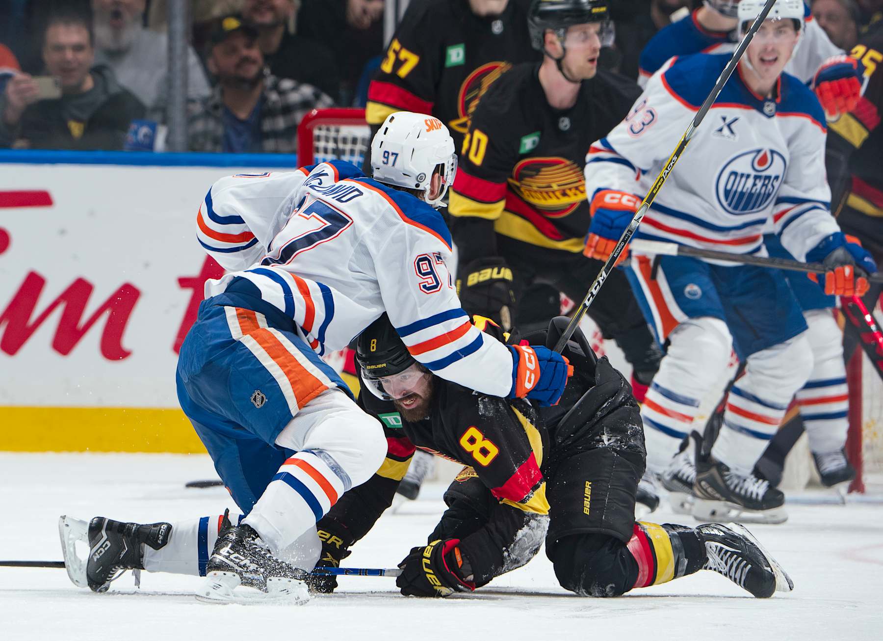 VANCOUVER, CANADA - JANUARY 18: Connor McDavid #97 of the Edmonton Oilers checks Conor Garland #8 of the Vancouver Canucks during the third period of their NHL game at Rogers Arena on January 18, 2025 in Vancouver, British Columbia, Canada. Vancouver won 3-2. (Photo by Jeff Vinnick/NHLI via Getty Images)