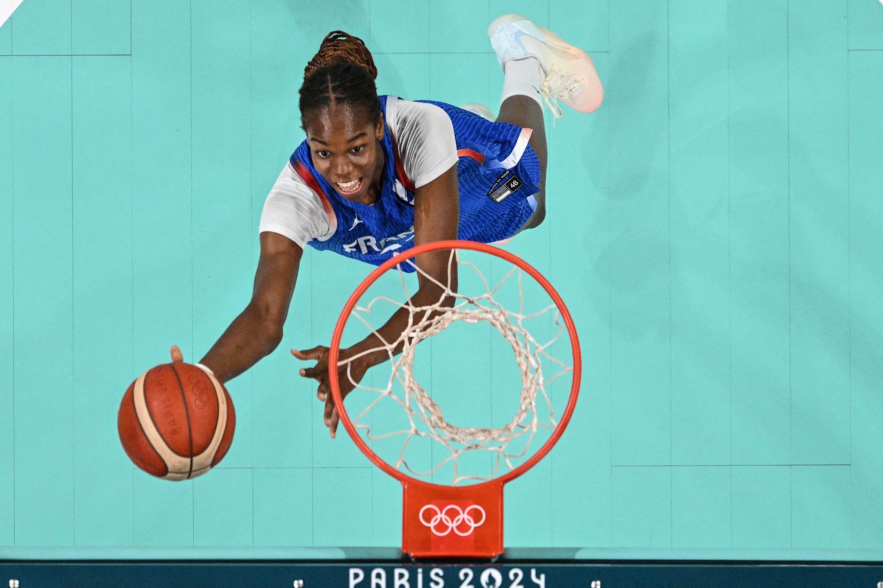 An overview shows France's #14 Dominique Malonga laying up a ball in the women's preliminary round group B basketball match between Canada and France during the Paris 2024 Olympic Games at the Pierre-Mauroy stadium in Villeneuve-d'Ascq, northern France, on July 29, 2024. (Photo by Antonin THUILLIER / POOL / AFP) (Photo by ANTONIN THUILLIER/POOL/AFP via Getty Images)
