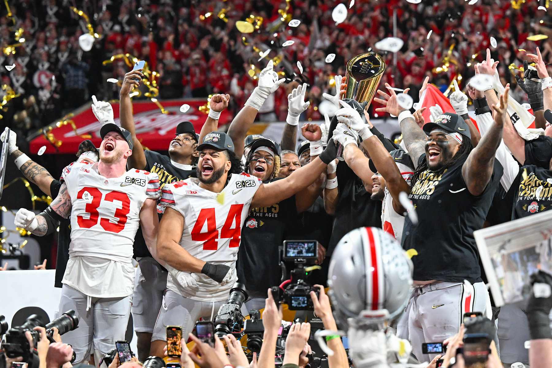 ATLANTA, GA  JANUARY 20:  Ohio State players celebrate with the winning trophy following the conclusion of the the Ohio State Buckeyes versus Notre Dame Fighting Irish College Football Playoff National Championship game on January 20, 2025, at Mercedes-Benz Stadium in Atlanta, GA.  (Photo by Rich von Biberstein/Icon Sportswire via Getty Images)