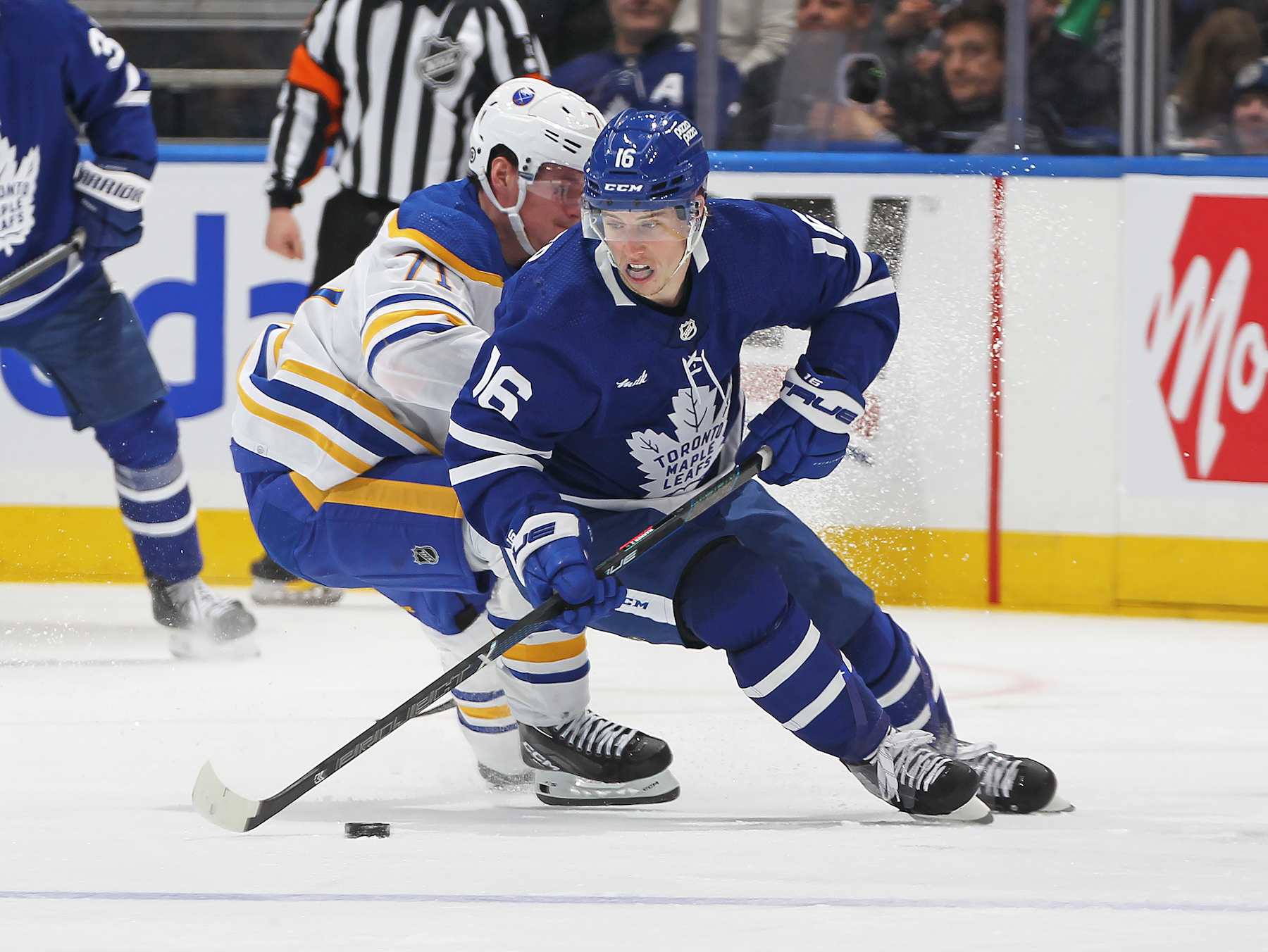 TORONTO, CANADA - MARCH 6: Mitchell Marner #16 of the Toronto Maple Leafs turns with the puck against Victor Olofsson #71 of the Buffalo Sabres during the third period in an NHL game at Scotiabank Arena on March 6, 2024 in Toronto, Ontario, Canada. The Maple Leafs defeated the Sabres 2-1 in overtime. (Photo by Claus Andersen/Getty Images)
