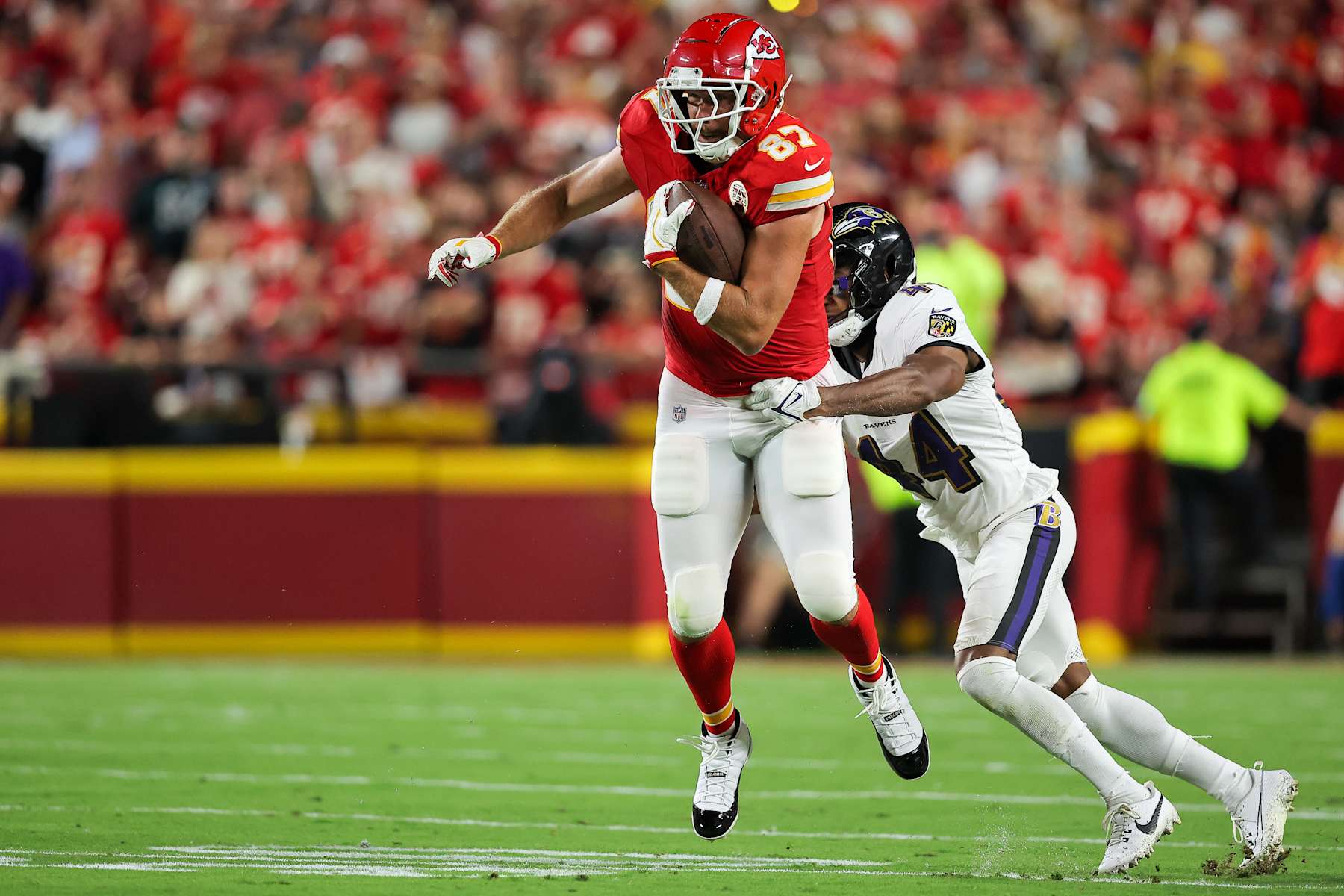 KANSAS CITY, MISSOURI - SEPTEMBER 5: Travis Kelce #87 of the Kansas City Chiefs runs after a second quarter pass catch past Marlon Humphrey #44 of the Baltimore Ravens at GEHA Field at Arrowhead Stadium on September 5, 2024 in Kansas City, Missouri. (Photo by David Eulitt/Getty Images)