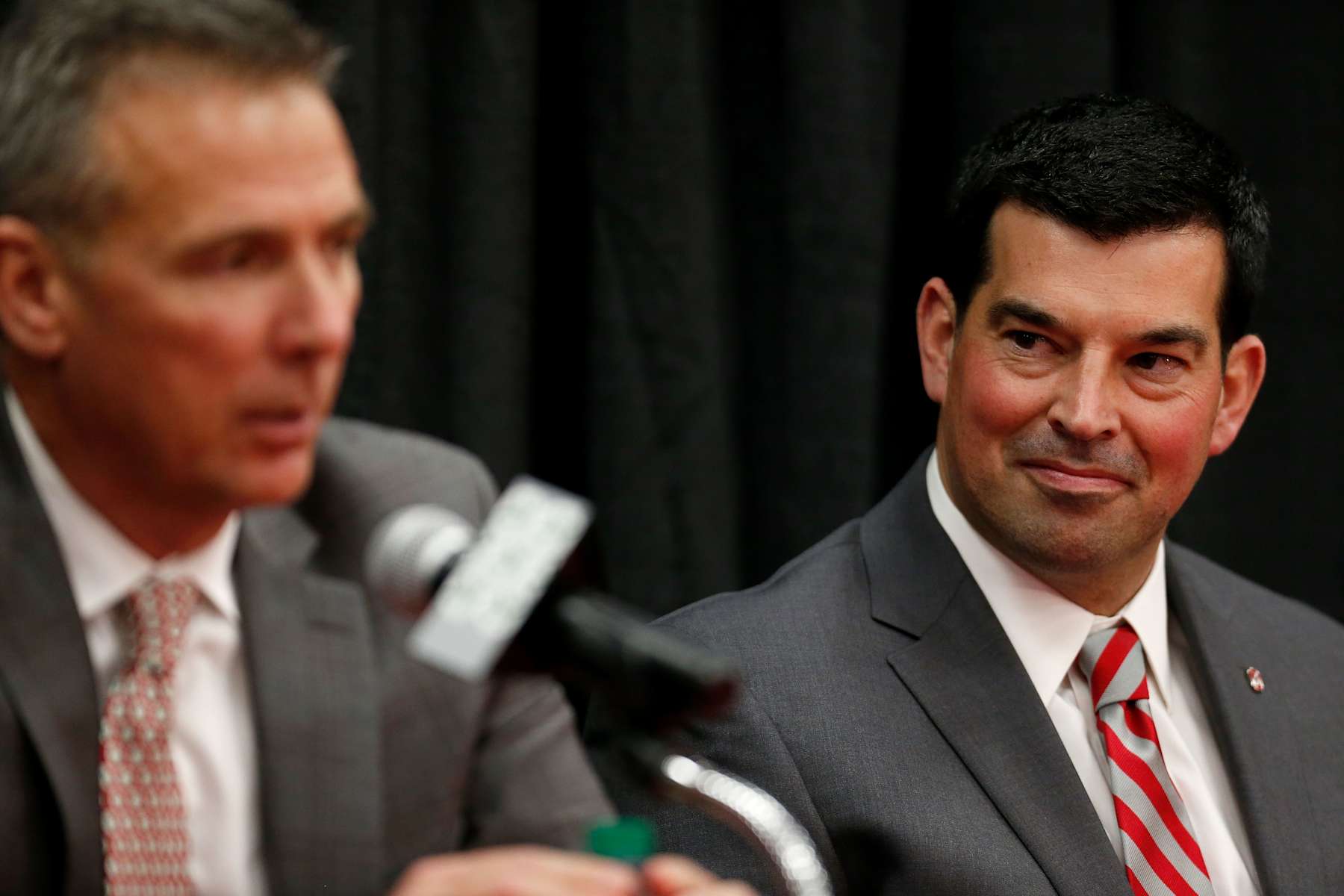 COLUMBUS, OH - DECEMBER 04:  Offensive coordinator Ryan Day of the Ohio State Buckeyes listens as head coach Urban Meyer answers a question during a press conference at Ohio State University on December 4, 2018 in Columbus, Ohio. At the press conference Meyer announced his retirement and Day was announced as the next head coach. Meyer will continue to coach until after the Ohio State Buckeyes play in the Rose Bowl. (Photo by Kirk Irwin/Getty Images)