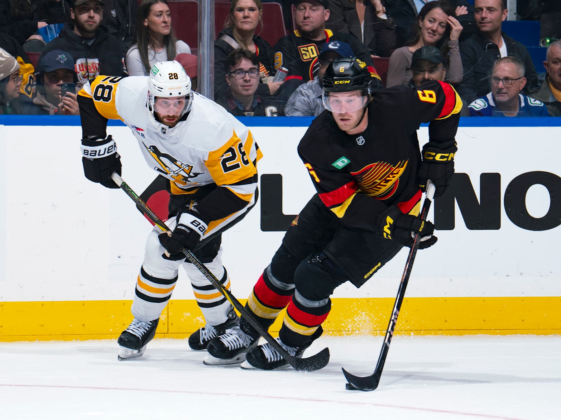 VANCOUVER, CANADA - OCTOBER 26: Marcus Pettersson #28 of the Pittsburgh Penguins checks Brock Boeser #6 of the Vancouver Canucks during their NHL game at Rogers Arena on October 26, 2024 in Vancouver, British Columbia, Canada. (Photo by Jeff Vinnick/NHLI via Getty Images)