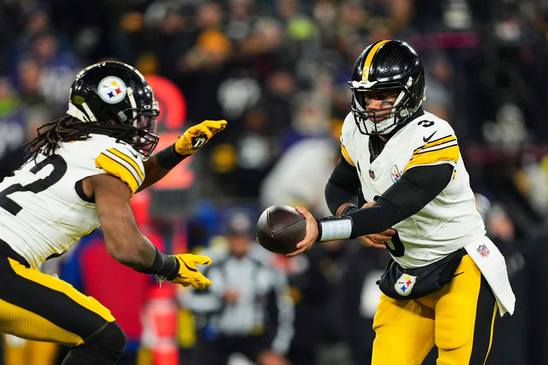 BALTIMORE, MD - JANUARY 11: Russell Wilson #3 of the Pittsburgh Steelers hands the ball off during an NFL football wild card playoff game against the Baltimore Ravens at M&T Bank Stadium on January 11, 2025 in Baltimore, Maryland. (Photo by Cooper Neill/Getty Images)