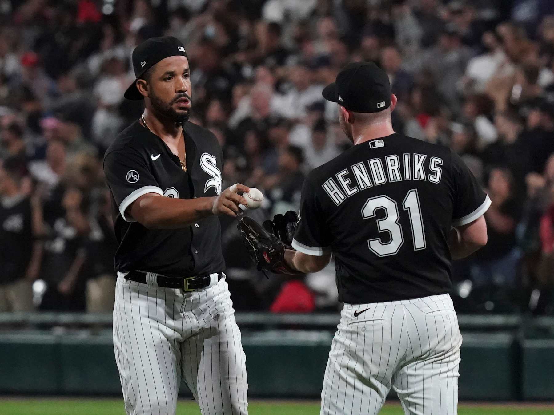 CHICAGO, ILLINOIS - JULY 30: Jose Abreu #79 of the Chicago White Sox hands Liam Hendriks #31 the ball from the last out following their team's win over the Cleveland Indians at Guaranteed Rate Field on July 30, 2021 in Chicago, Illinois. (Photo by Nuccio DiNuzzo/Getty Images)