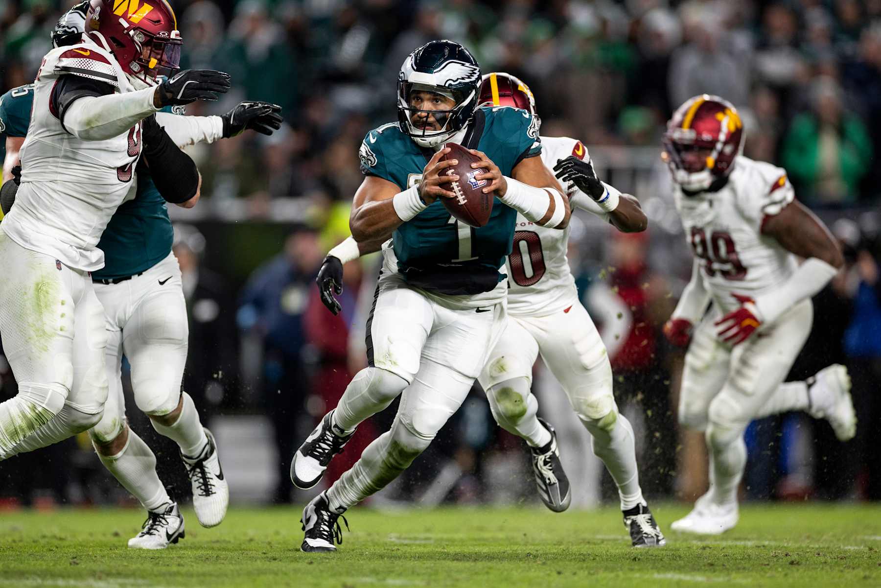 PHILADELPHIA, PENNSYLVANIA - NOVEMBER 14: Jalen Hurts #1 of the Philadelphia Eagles scrambles and looks to pass during an NFL Football game against the Washington Commanders at Lincoln Financial Field on November 14, 2024 in Philadelphia, Pennsylvania. (Photo by Michael Owens/Getty Images)
