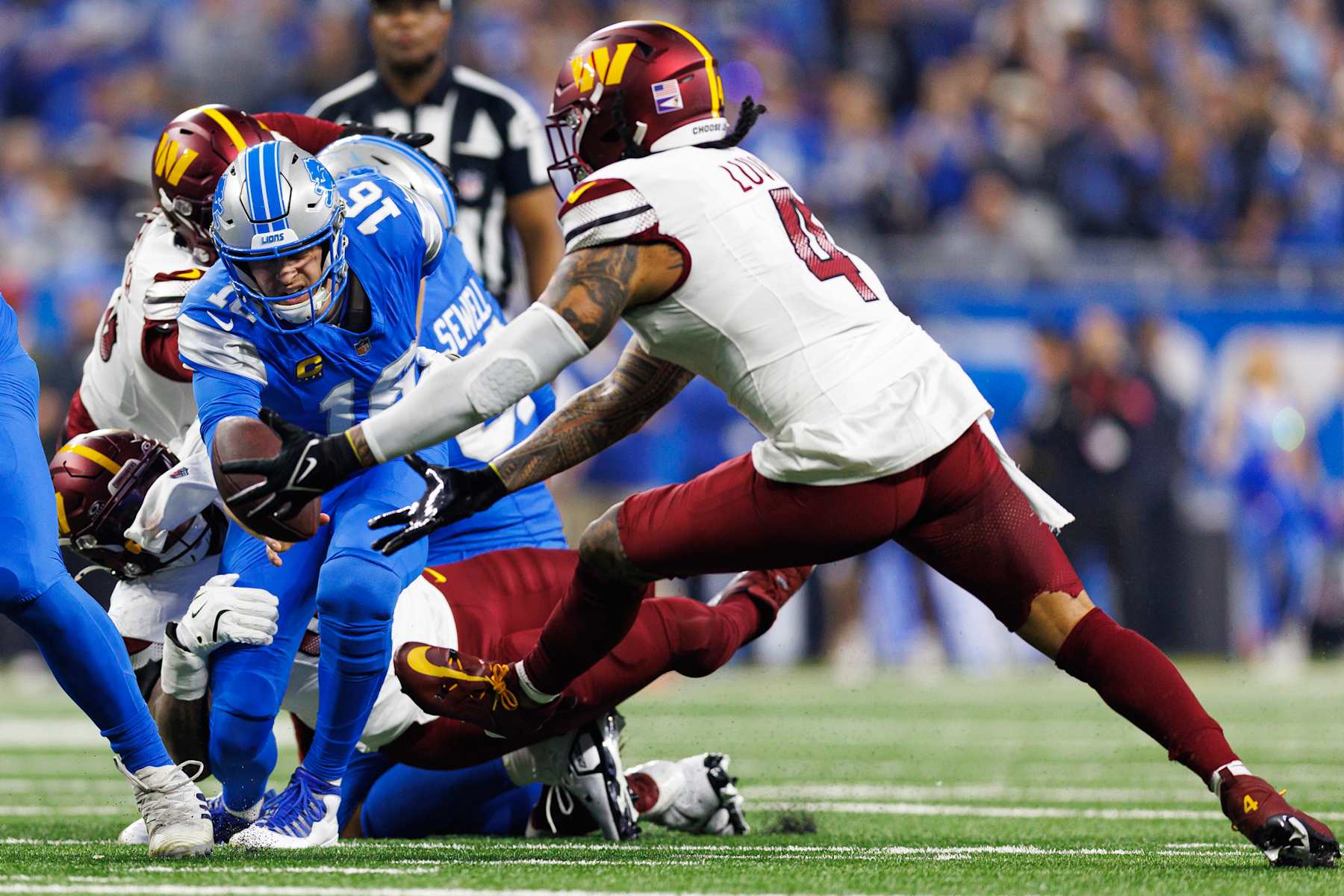 DETROIT, MICHIGAN - JANUARY 18: Linebacker Frankie Luvu #4 of the Washington Commanders recovers a fumble during the first half of an NFL football divisional playoff game against the Detroit Lions, at Ford Field on January 18, 2025 in Detroit, Michigan. (Photo by Brooke Sutton/Getty Images)