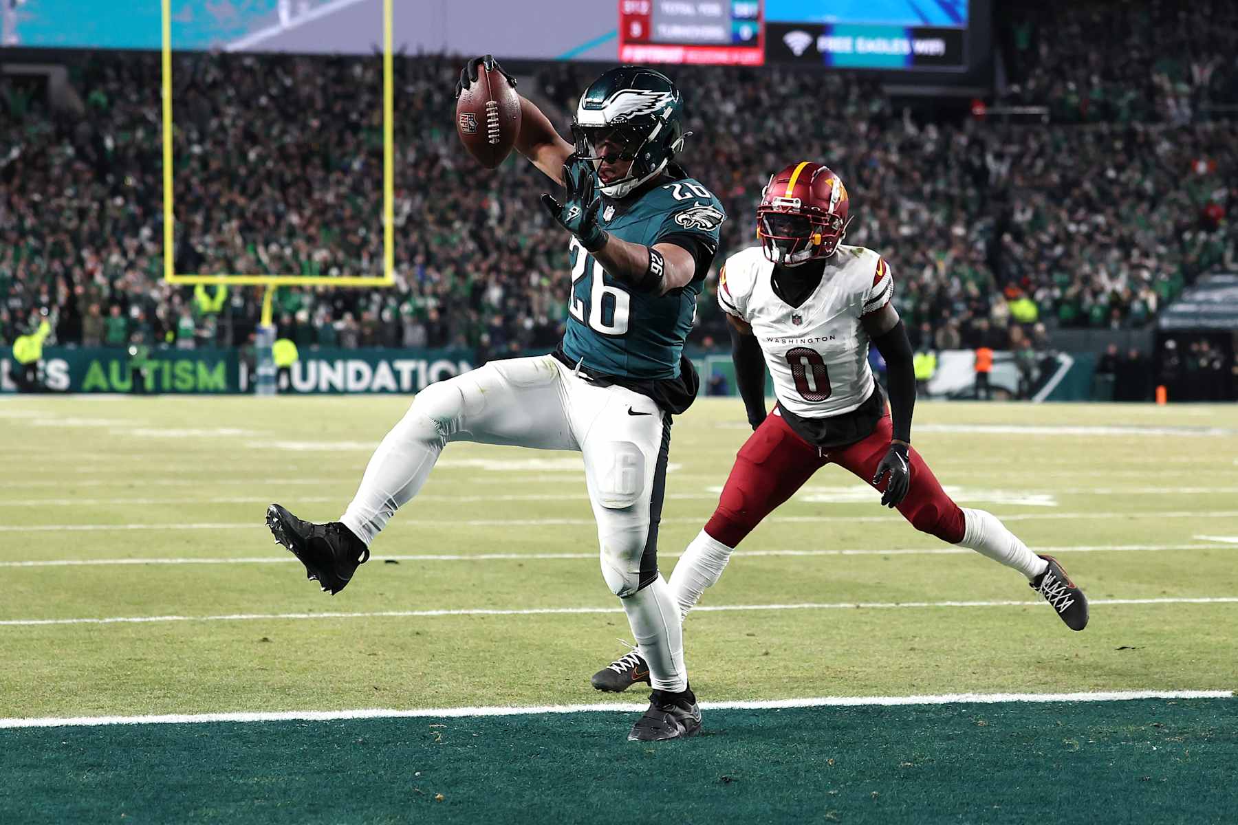 PHILADELPHIA, PENNSYLVANIA - JANUARY 26: Saquon Barkley #26 of the Philadelphia Eagles scores a touchdown against Mike Sainristil #0 of the Washington Commanders during the fourth quarter in the NFC Championship Game at Lincoln Financial Field on January 26, 2025 in Philadelphia, Pennsylvania. (Photo by Emilee Chinn/Getty Images)
