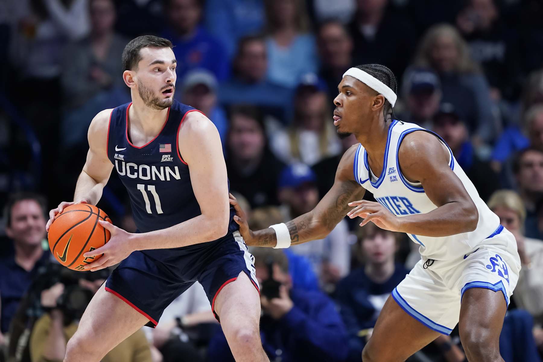 CINCINNATI, OHIO - JANUARY 25: Alex Karaban #11 of the Connecticut Huskies handles the ball while being guarded by Ryan Conwell #7 of the Xavier Musketeers in the first half at the Cintas Center on January 25, 2025 in Cincinnati, Ohio. (Photo by Dylan Buell/Getty Images)