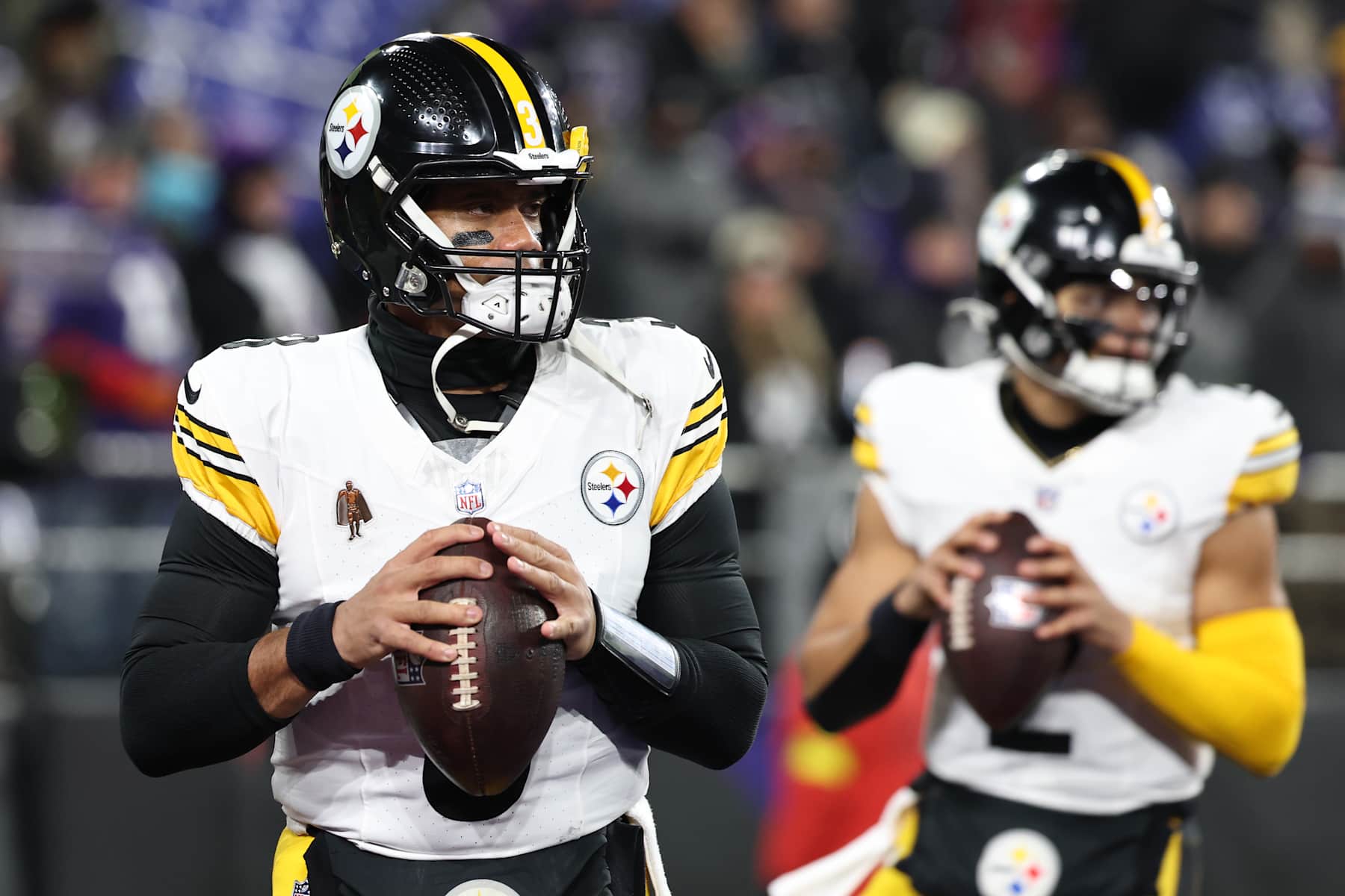 BALTIMORE, MARYLAND - JANUARY 11: Russell Wilson #3 and Justin Fields #2 of the Pittsburgh Steelers warms up prior to the game against the Baltimore Ravens during the AFC Wild Card Playoff at M&T Bank Stadium on January 11, 2025 in Baltimore, Maryland.  (Photo by Scott Taetsch/Getty Images)