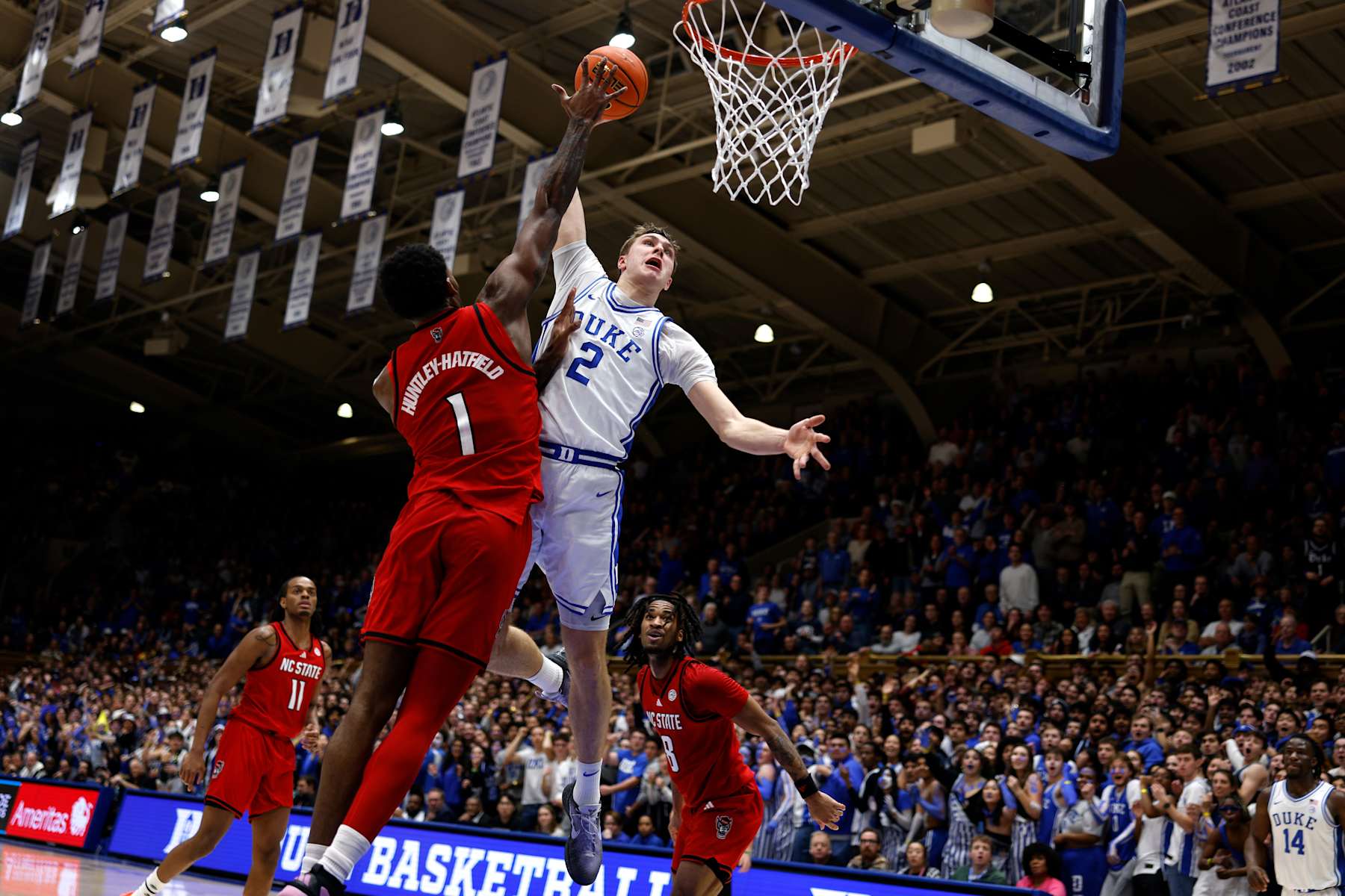 DURHAM, NORTH CAROLINA - JANUARY 27: Cooper Flagg #2 of the Duke Blue Devils is fouled by Brandon Huntley-Hatfield #1 of the NC State Wolfpack during a dunk attempt in the first half at Cameron Indoor Stadium on January 27, 2025 in Durham, North Carolina. (Photo by Lance King/Getty Images)