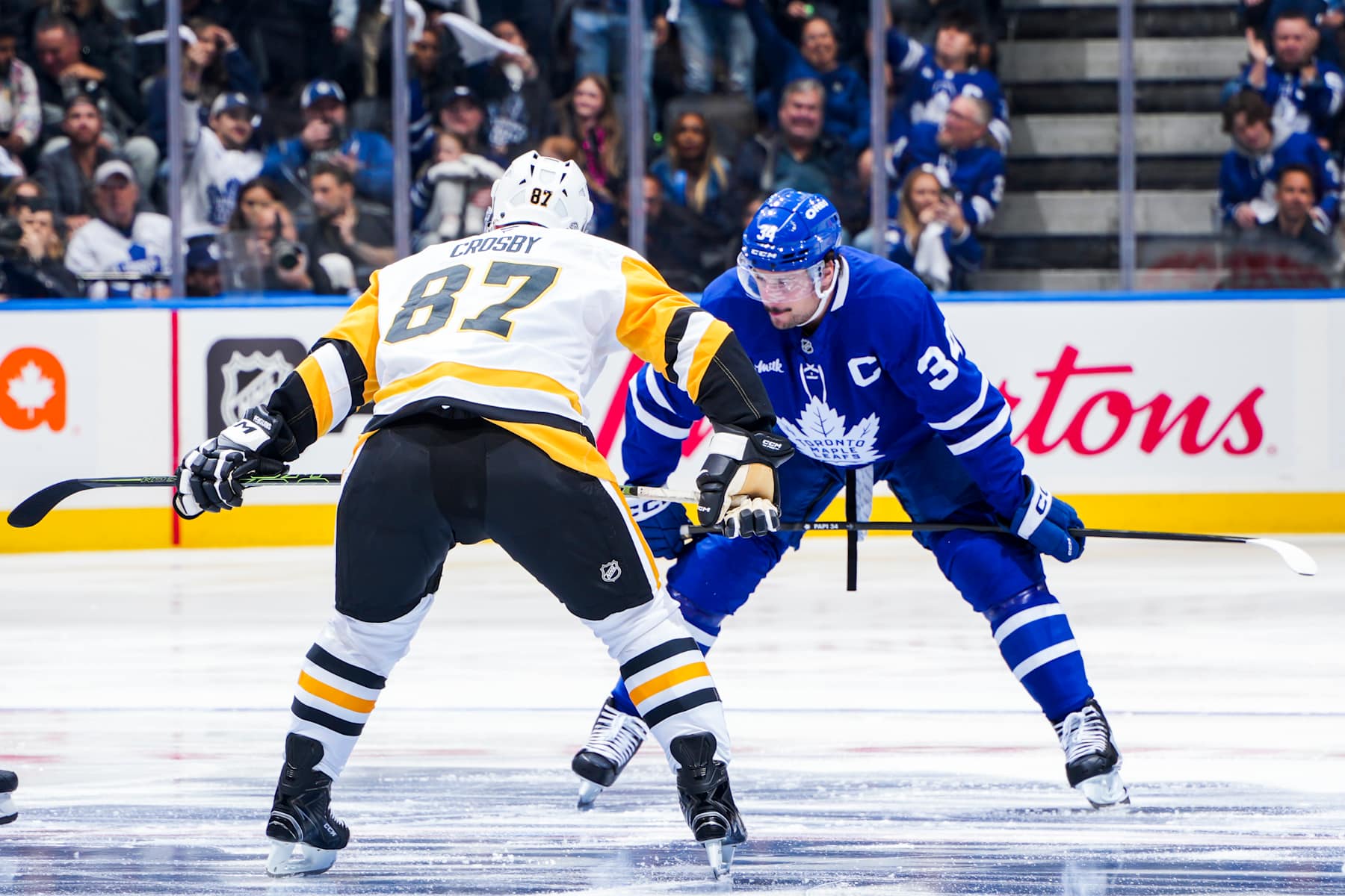 TORONTO, ONTARIO - OCTOBER 12: Auston Matthews #34 of the Toronto Maple and Sidney Crosby #87 of the Pittsburgh Penguins during the opening face-off of the Toronto Maple Leafs Home Opener at the Scotiabank Arena on October 12, 2024 in Toronto, Ontario, Canada. (Photo by Mark Blinch/NHLI via Getty Images)