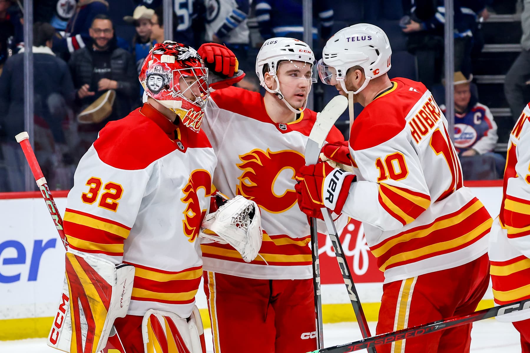 WINNIPEG, CANADA - JANUARY 18: Goaltender Dustin Wolf #32, Rory Kerins #86 and Jonathan Huberdeau #10 of the Calgary Flames celebrate following a 3-1 victory over the Winnipeg Jets at the Canada Life Centre on January 18, 2025 in Winnipeg, Manitoba, Canada. (Photo by Jonathan Kozub/NHLI via Getty Images)