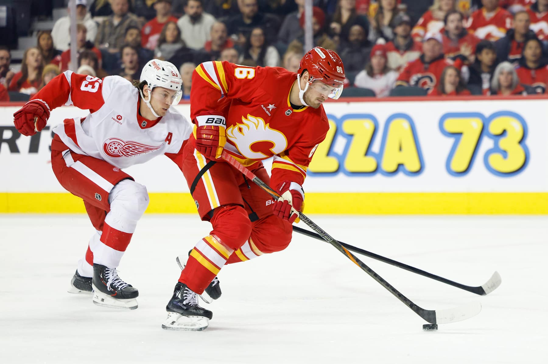 CALGARY, CANADA - FEBRUARY 01: Joel Farabee #86 of the Calgary Flames handles the puck against Moritz Seider #53 of the Detroit Red Wings during first period at the Scotiabank Saddledome on February 01, 2025, in Calgary, Alberta, Canada. (Photo by Leah Hennel/Getty Images)