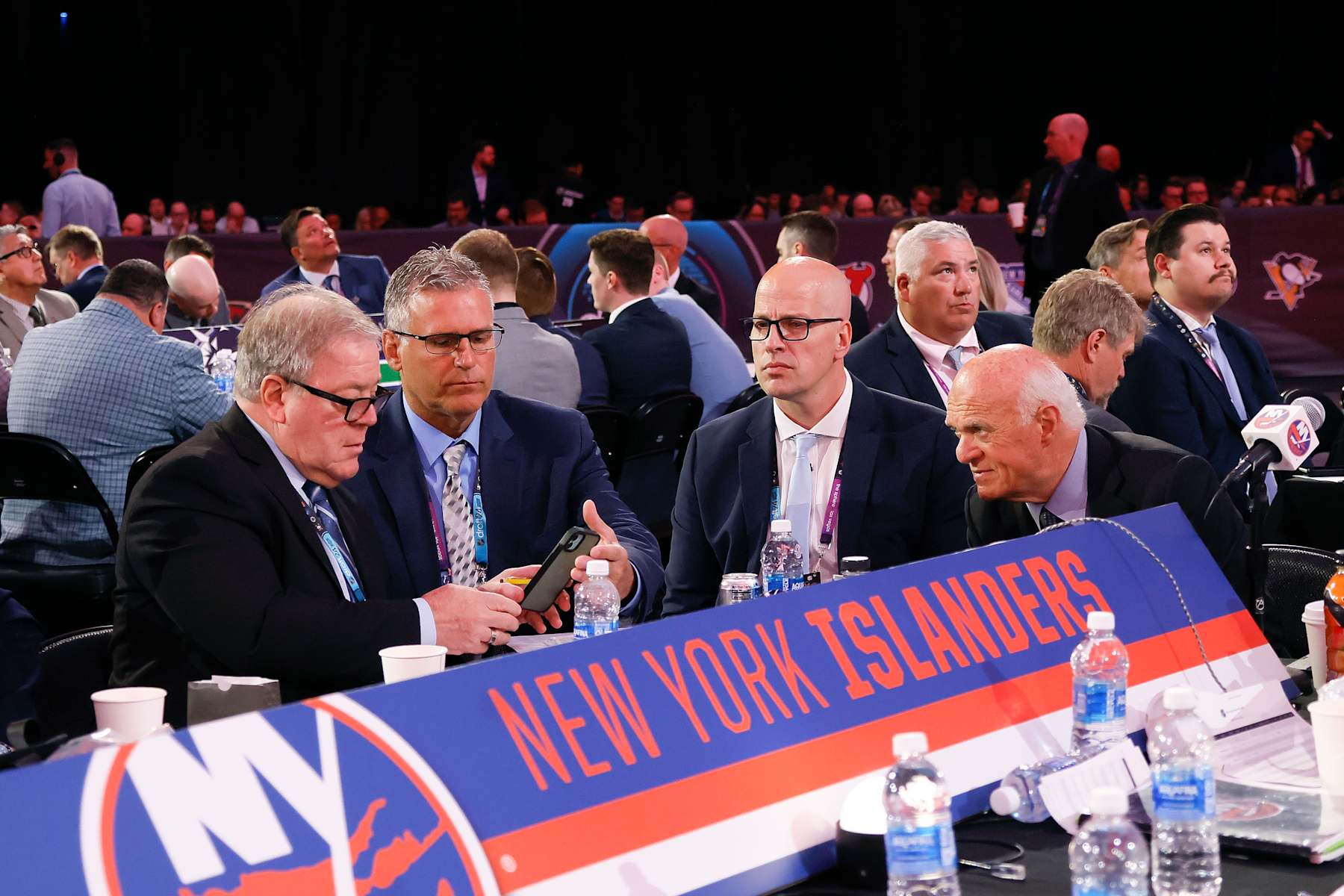 New York Islanders general manager Lou Lamoriello (right) confers with his staff during the 2024 NHL Draft.
