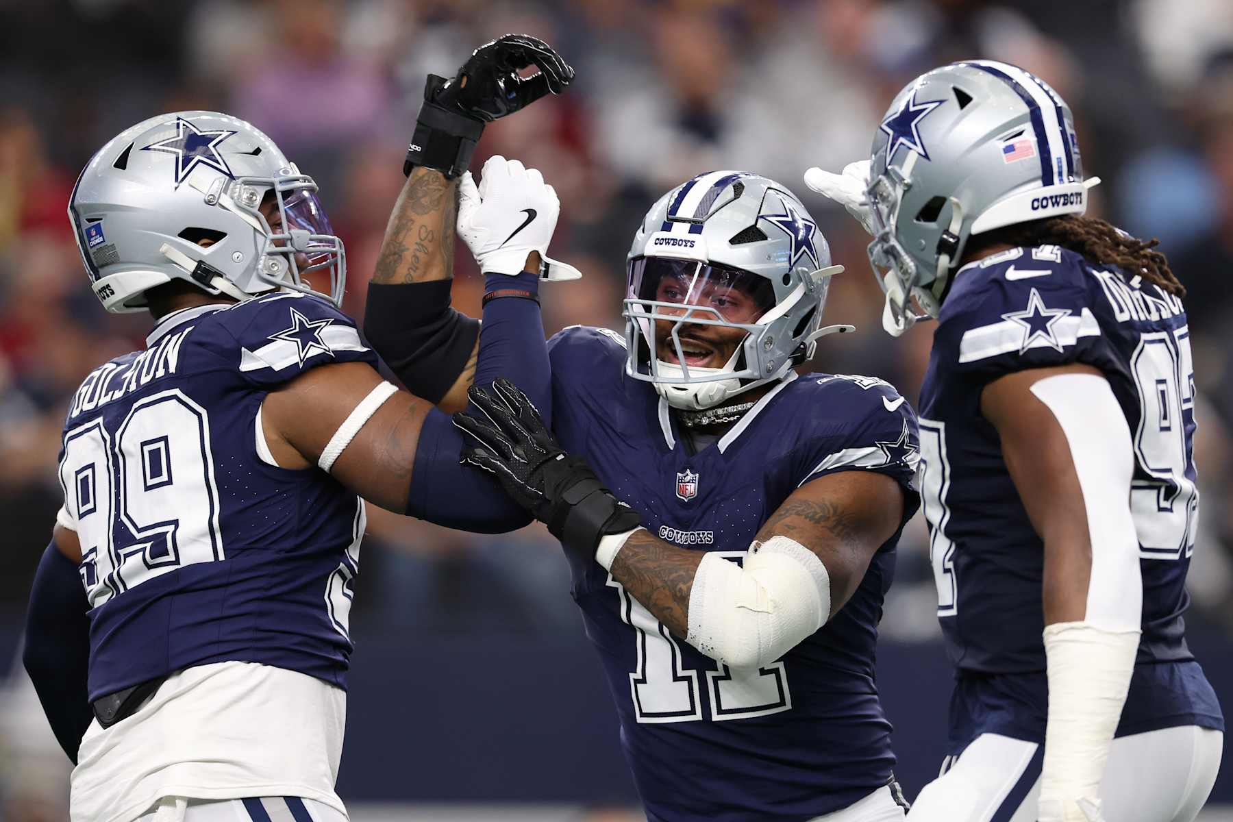 ARLINGTON, TEXAS - JANUARY 05: Micah Parsons #11 of the Dallas Cowboys celebrates with Chauncey Golston #99 and Osa Odighizuwa #97 after a sack during the first quarter against the Washington Commanders at AT&T Stadium on January 05, 2025 in Arlington, Texas. (Photo by Sam Hodde/Getty Images)